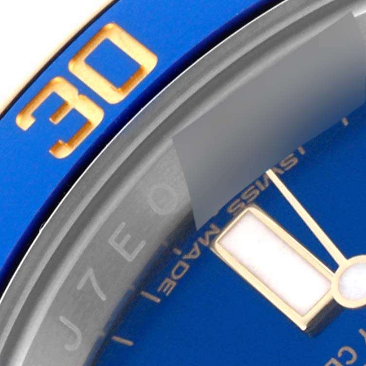 The close-up angle shows the bezel, part of the dial, and the hand of a Rolex Submariner 116613LB Men's Steel and Gold (two tone) Blue Dial 116613LB Men's Steel and Gold (two tone) Blue Dial watch.