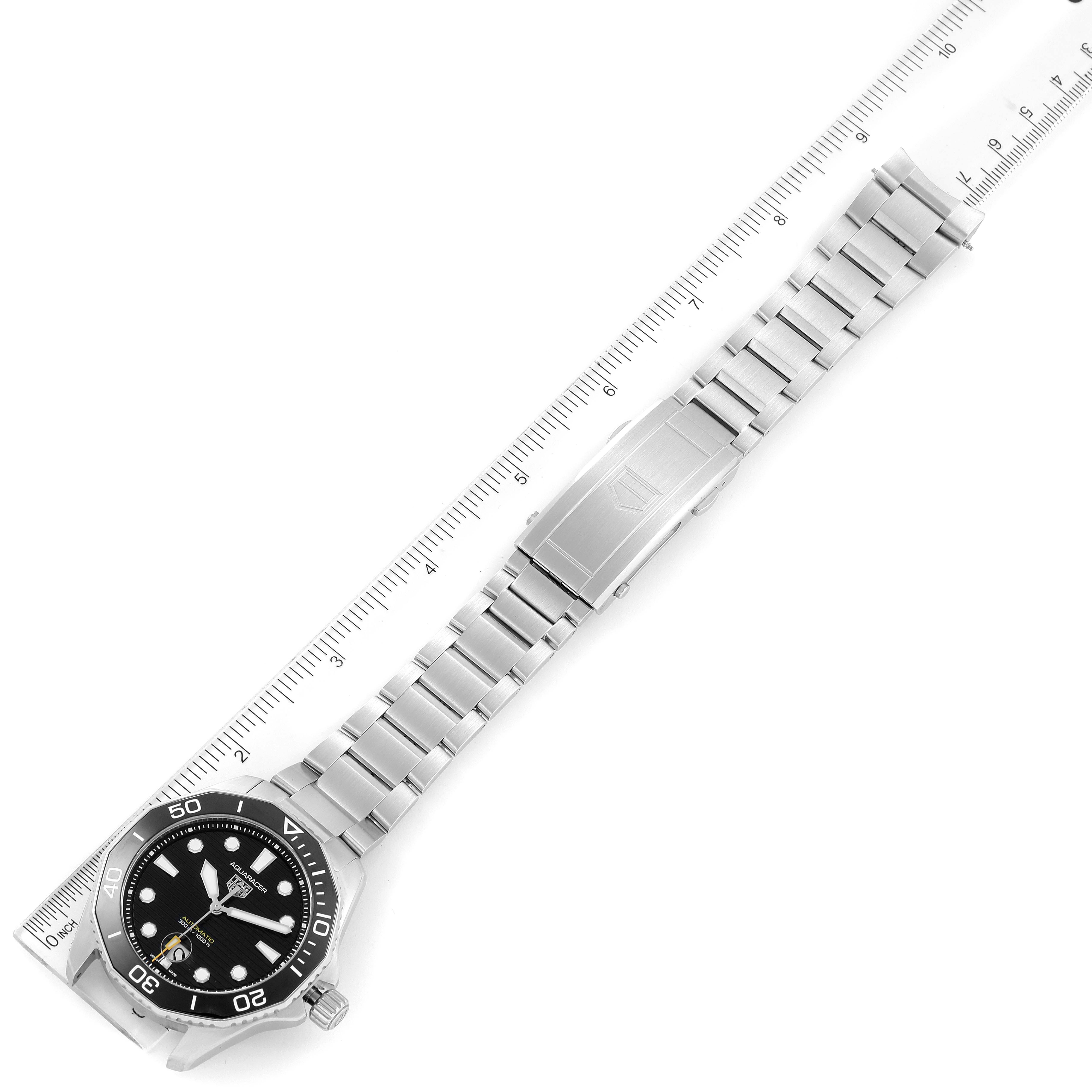 The image shows the Tag Heuer Aquaracer WBP201A.BA0632 Men's Stainless Steel Black Dial WBP201A.BA0632 Men's Stainless Steel Black Dial watch at an angle displaying the watch face, bezel, and metal bracelet near a ruler.