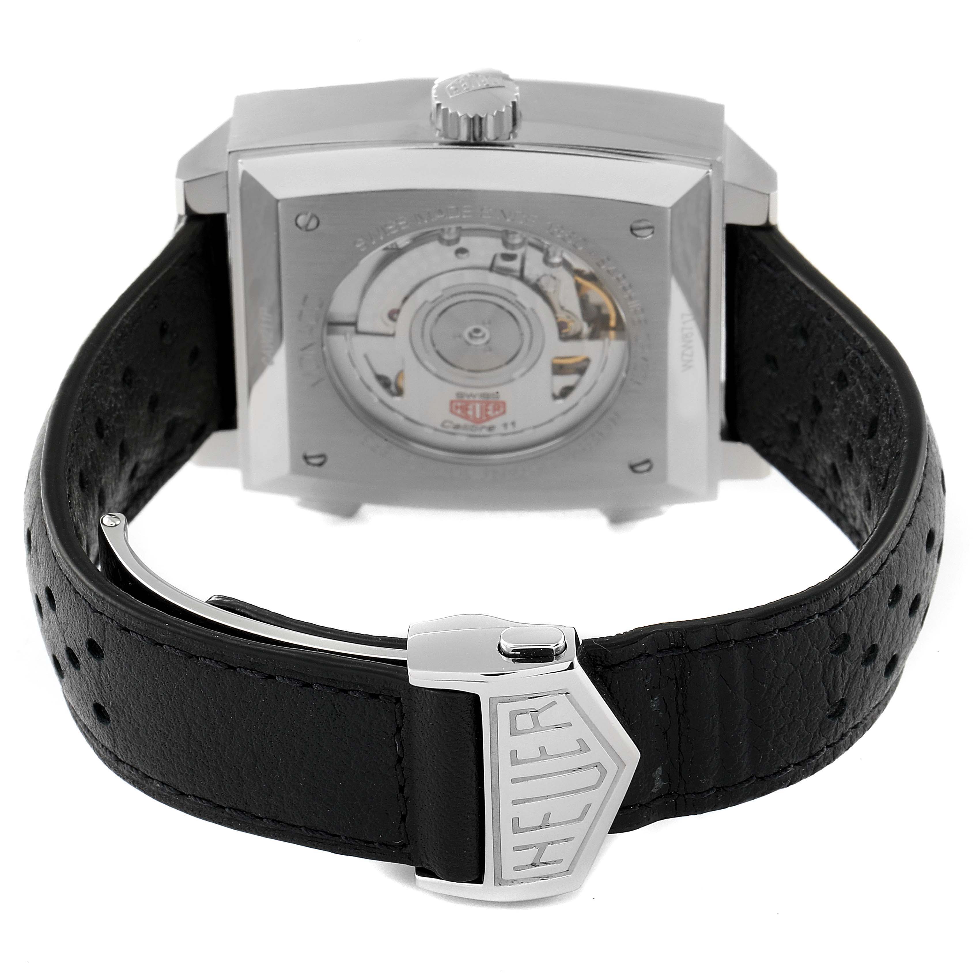 The image shows the back view of a Tag Heuer Monaco CAW211P Men's Stainless Steel Blue Dial CAW211P Men's Stainless Steel Blue Dial watch, highlighting its mechanical movement and leather strap with the 'Heuer' clasp.