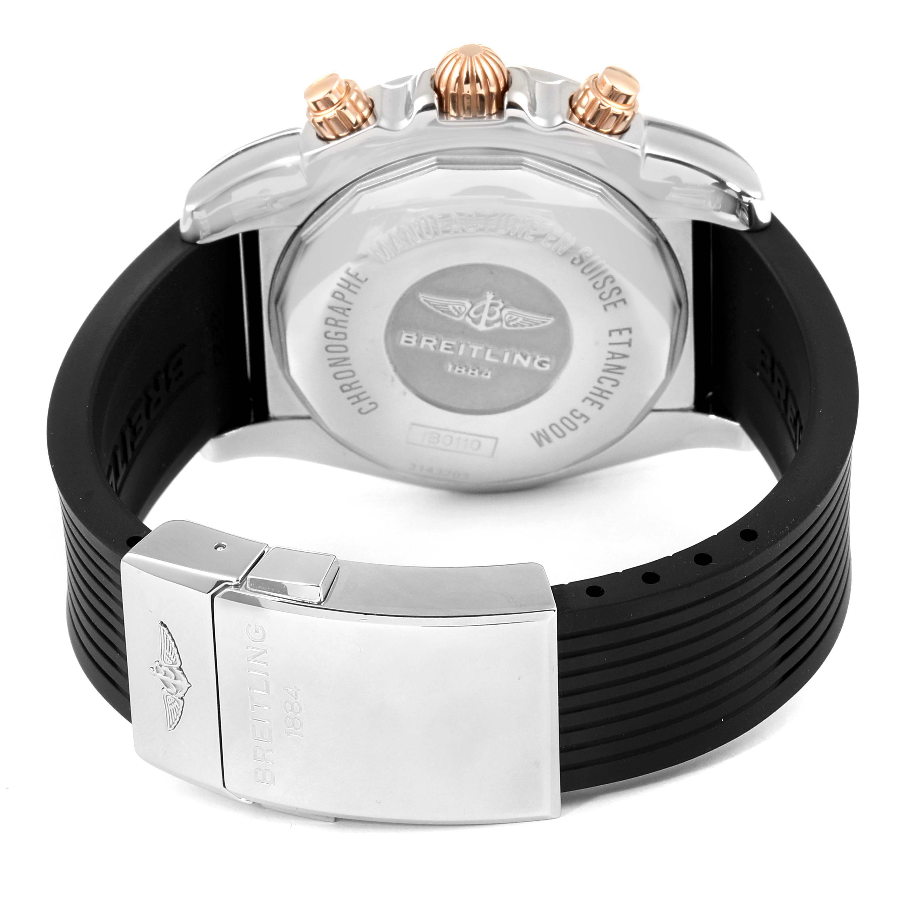 The image shows the back view of the Breitling Chronomat 1B0110 Men's Steel and Gold (two tone) Black Dial 1B0110 Men's Steel and Gold (two tone) Black Dial watch, highlighting the case back, crown, chronograph pushers, and rubber strap with a clasp.
