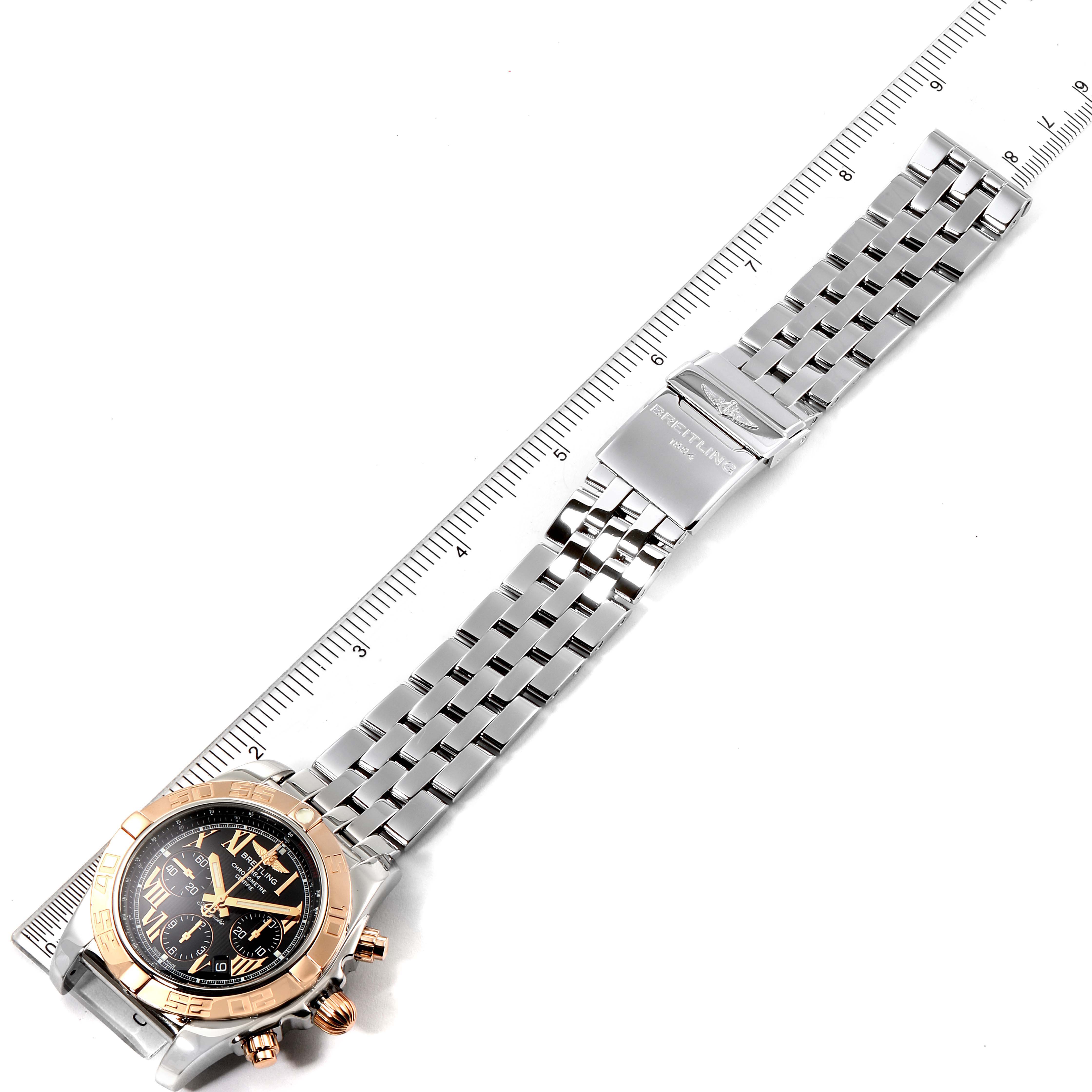 The image shows a top-down view of a Breitling Chronomat CB011012 Men's Steel and Gold (two tone) Black Dial CB011012 Men's Steel and Gold (two tone) Black Dial watch, displaying its full length, including the dial and metal bracelet.