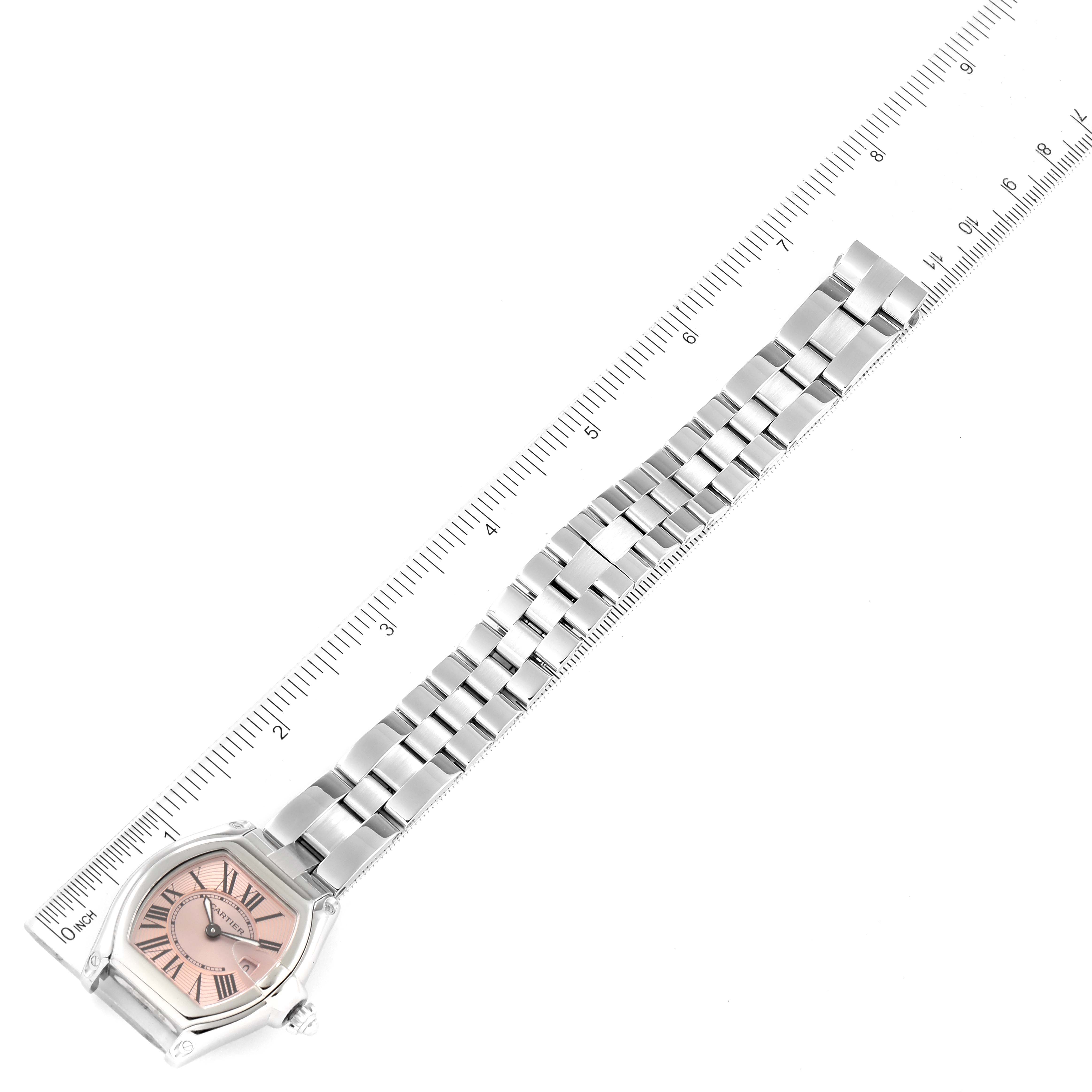 The Cartier Roadster W62017V3 Women's Stainless Steel Pink Dial W62017V3 Women's Stainless Steel Pink Dial watch is shown from a top-down angle, displaying the face and full metal bracelet alongside a ruler.
