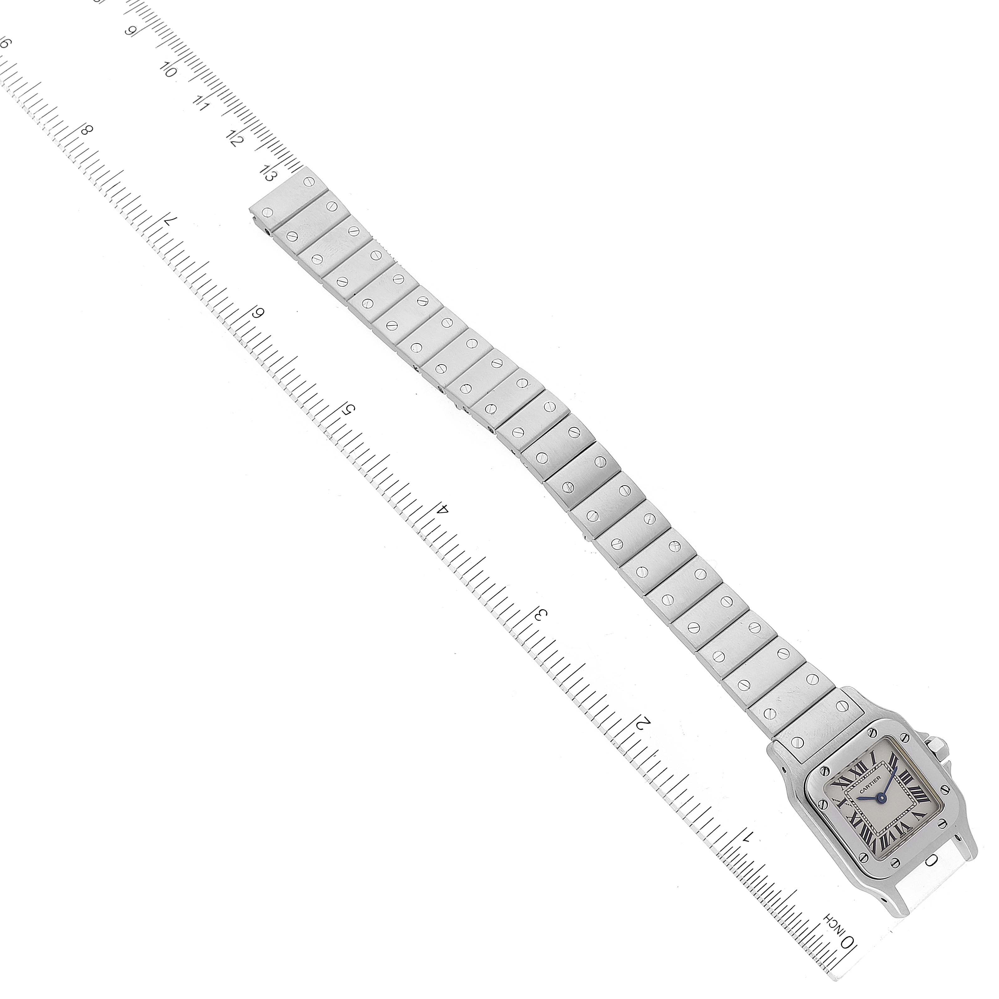 The Cartier Santos W20056D6 Women's Stainless Steel Silver Dial W20056D6 Women's Stainless Steel Silver Dial watch is shown flat with the entire bracelet and face visible, placed next to a ruler for scale.