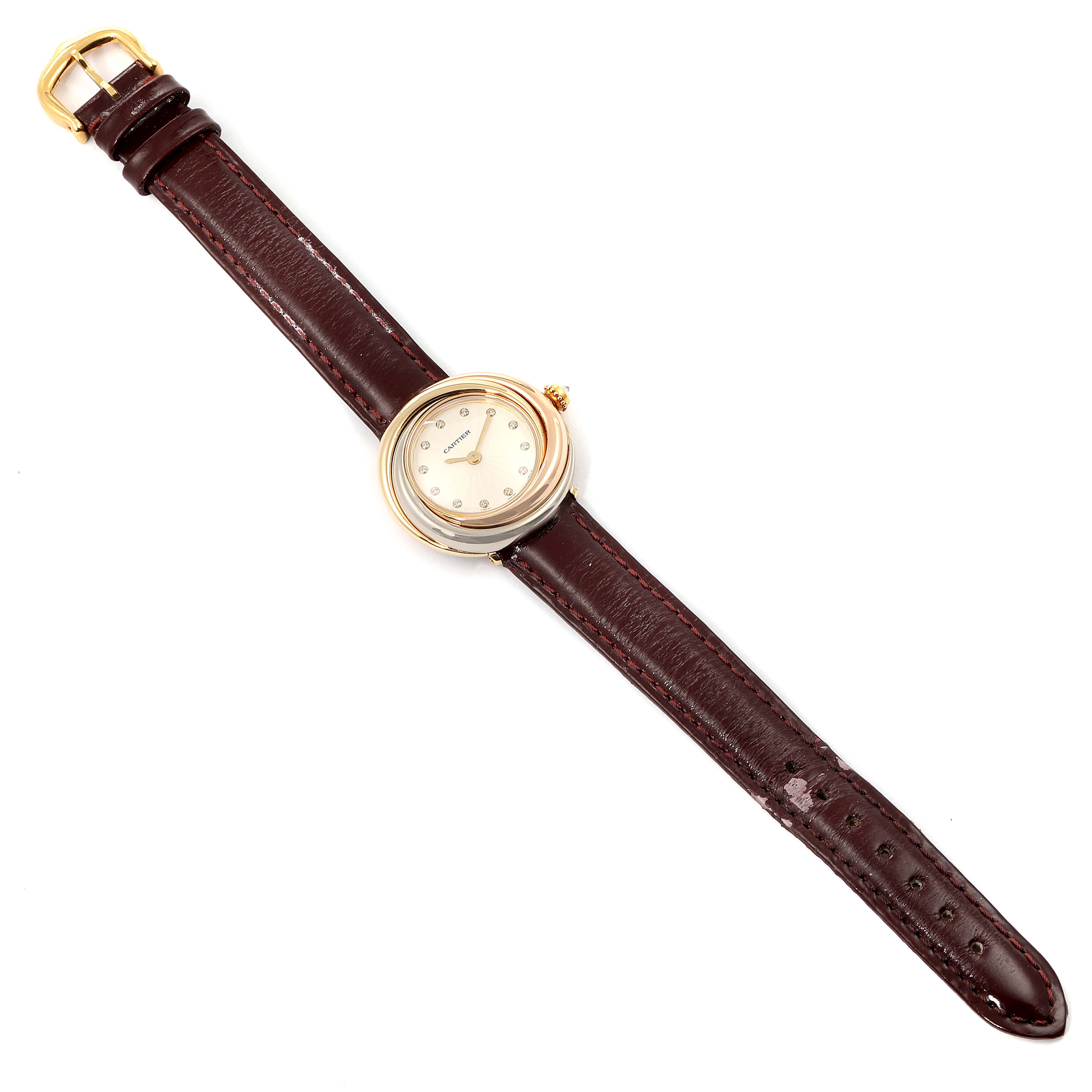 The image shows a top-down view of a Cartier Trinity W200246 Women's Yellow Gold Beige Dial W200246 Women's Yellow Gold Beige Dial model watch, displaying its circular face and brown leather strap.