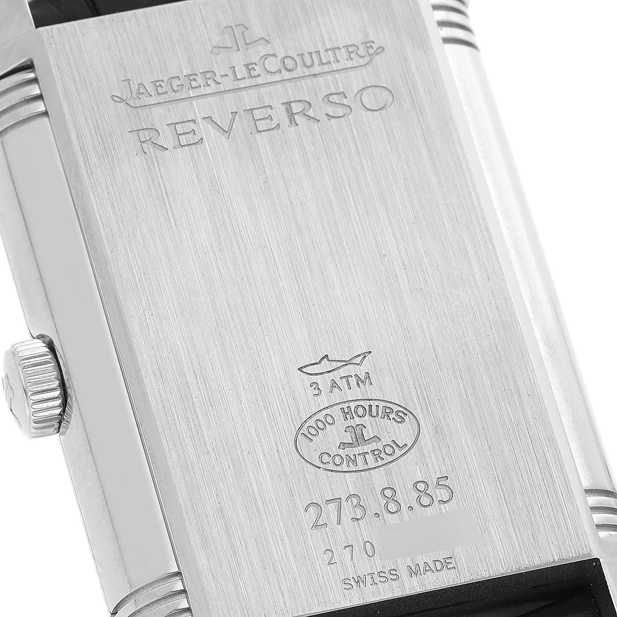 The image shows the back case of a Jaeger-LeCoultre Reverso watch, highlighting the engravings and the crown.