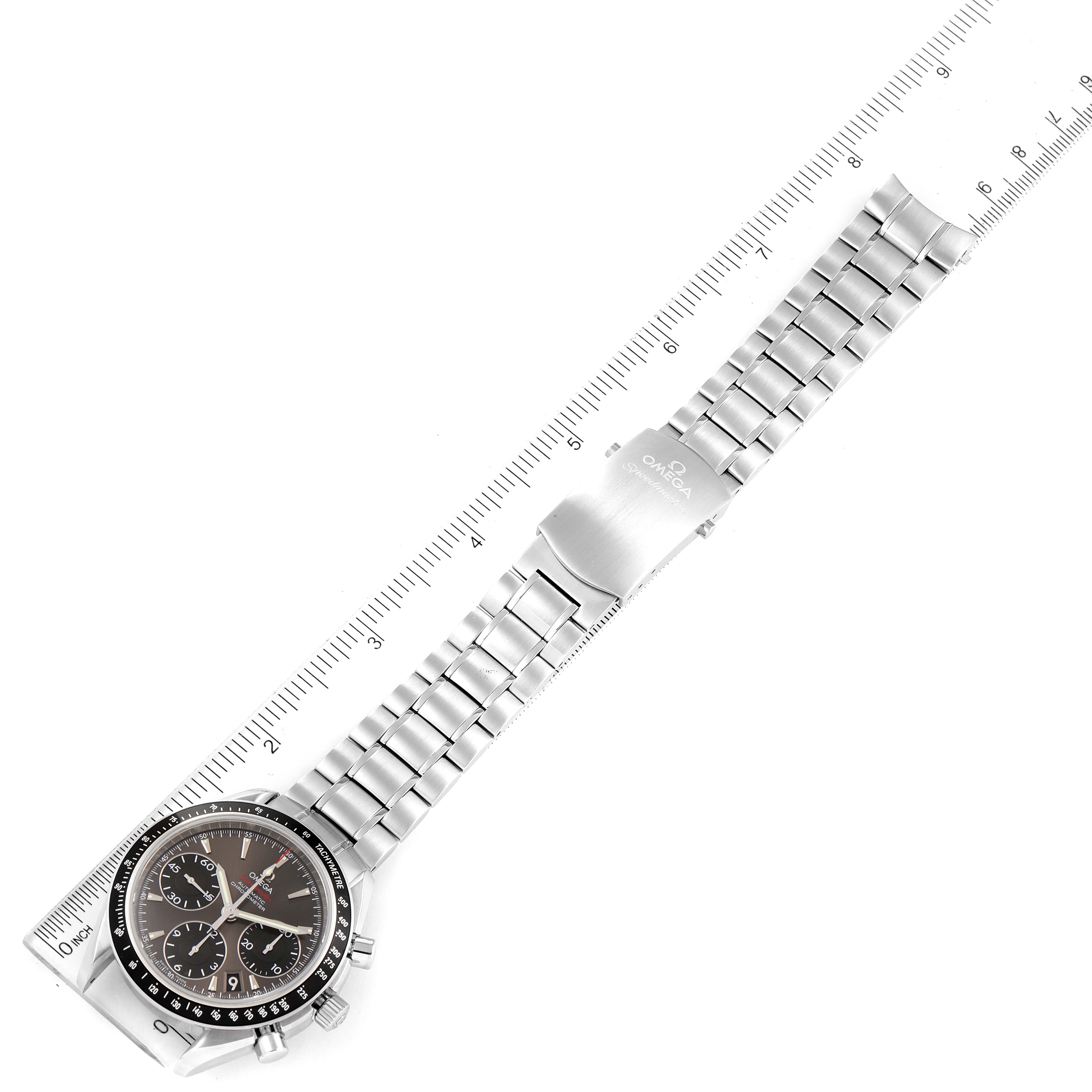 This image shows an Omega Speedmaster 323.30.40.40.06.001 Men's Stainless Steel Grey Dial 323.30.40.40.06.001 Men's Stainless Steel Grey Dial watch laying flat with its stainless steel band and clasp, alongside a ruler for size reference.