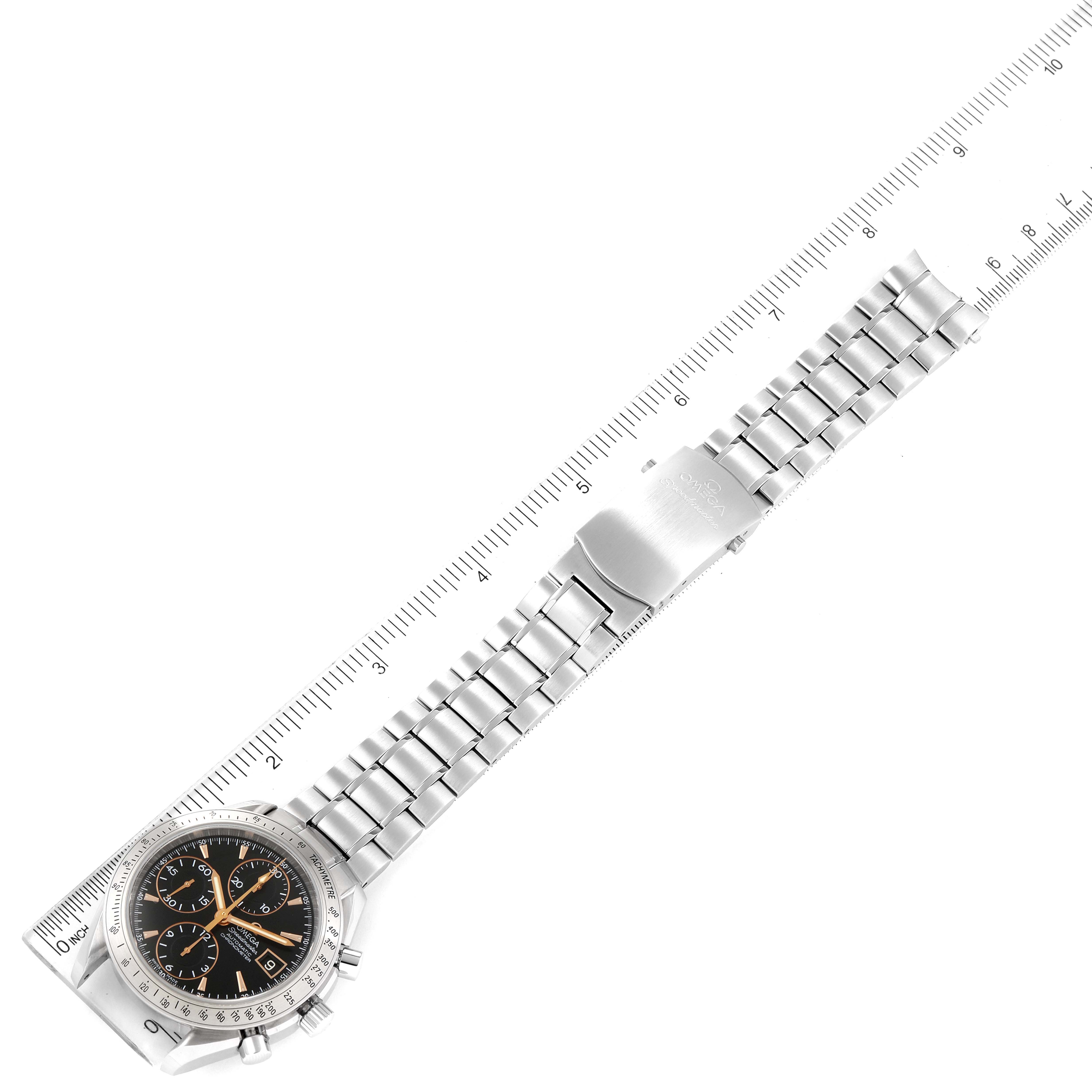 The Omega Speedmaster 3211.50.00 Men
s Stainless Steel Black Dial 3211.50.00 Men
s Stainless Steel Black Dial watch is shown from a top-down angle, displaying the face and metal bracelet next to a ruler for scale.