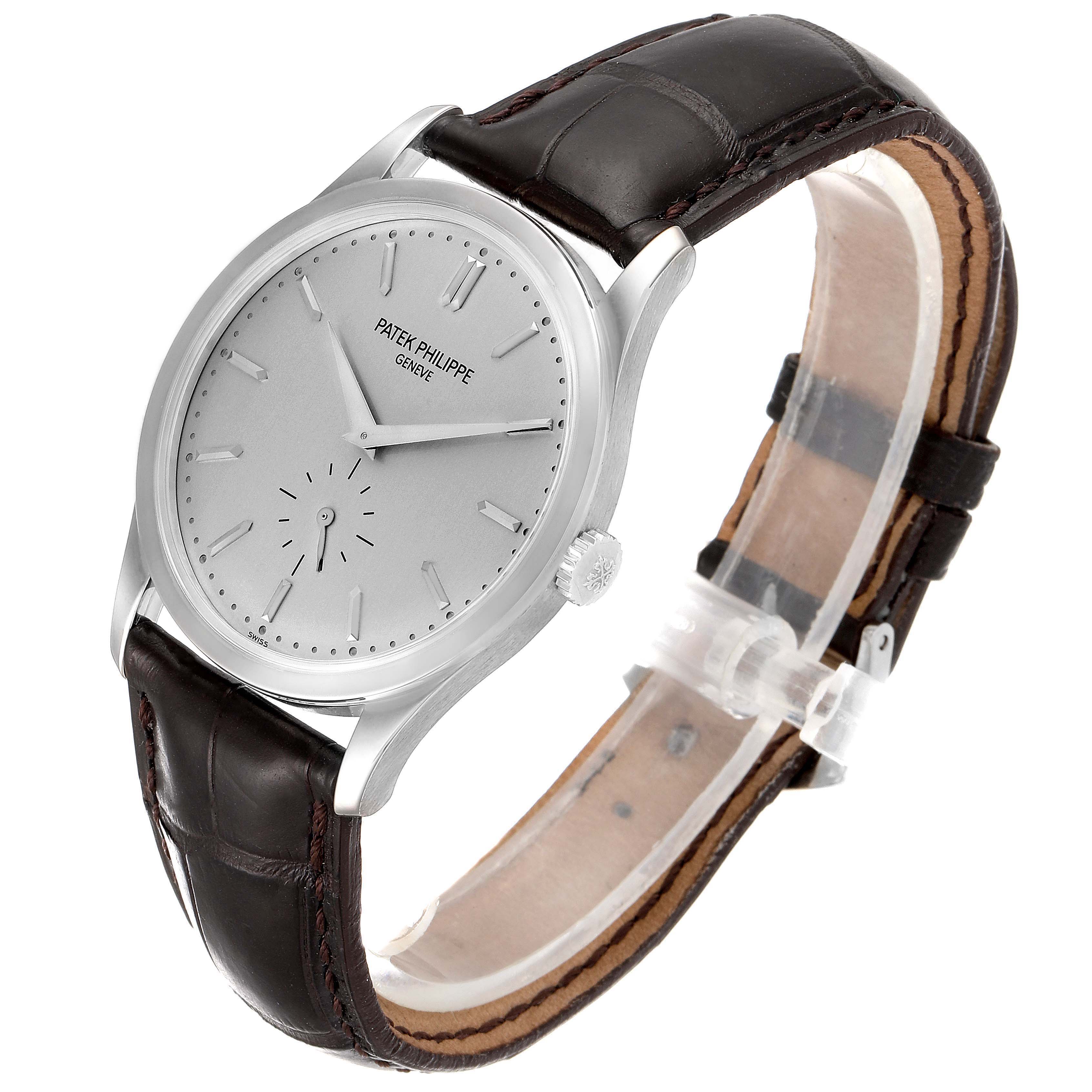 The Patek Philippe Calatrava 5196G Men's White Gold Silver Dial 5196G Men's White Gold Silver Dial watch is shown from an angled side view, highlighting its round dial, crown, and leather strap.
