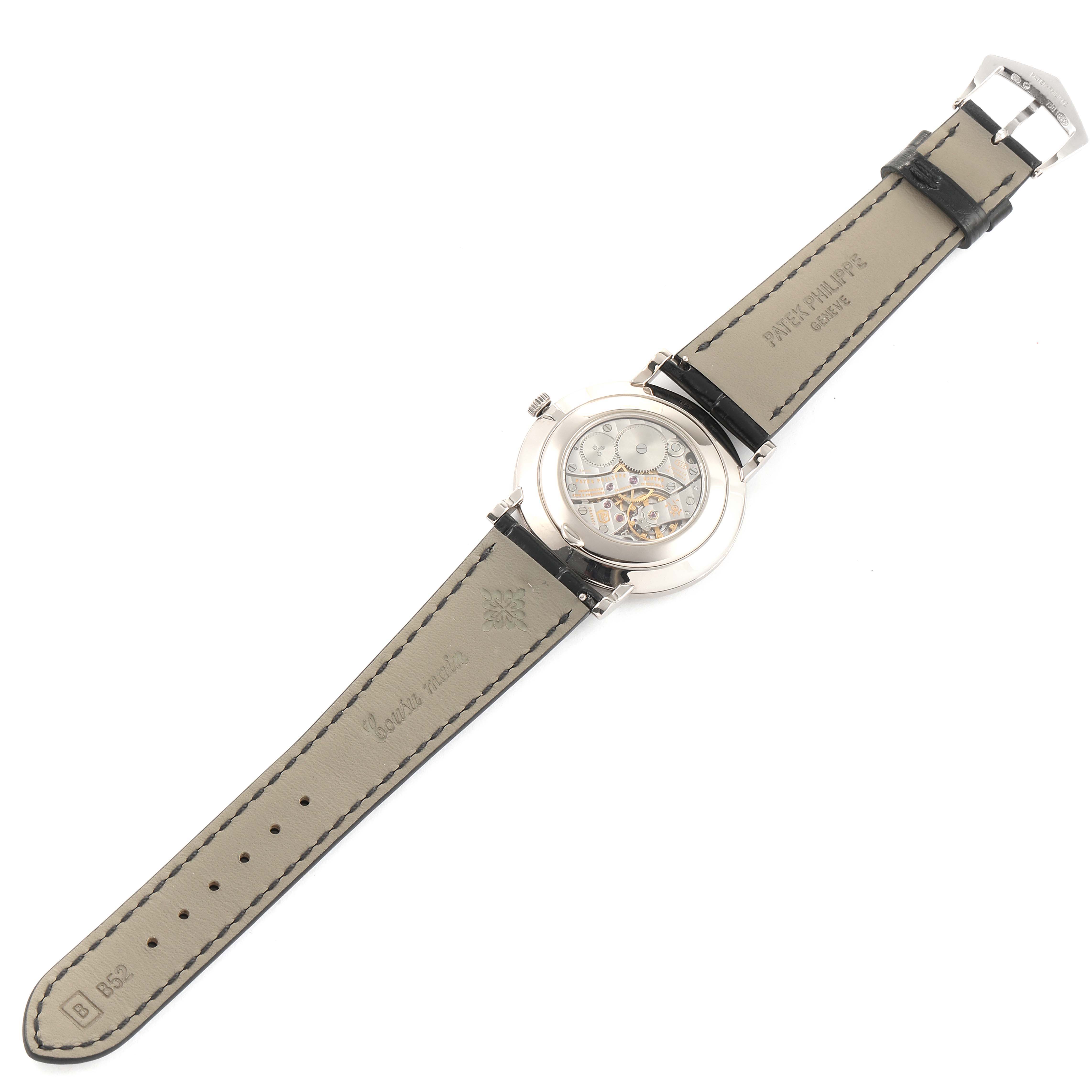 The image shows the back view of a Patek Philippe Calatrava 5119G Men
s White Gold White Dial 5119G Men
s White Gold White Dial watch, highlighting the leather strap and the transparent case back displaying the movement.