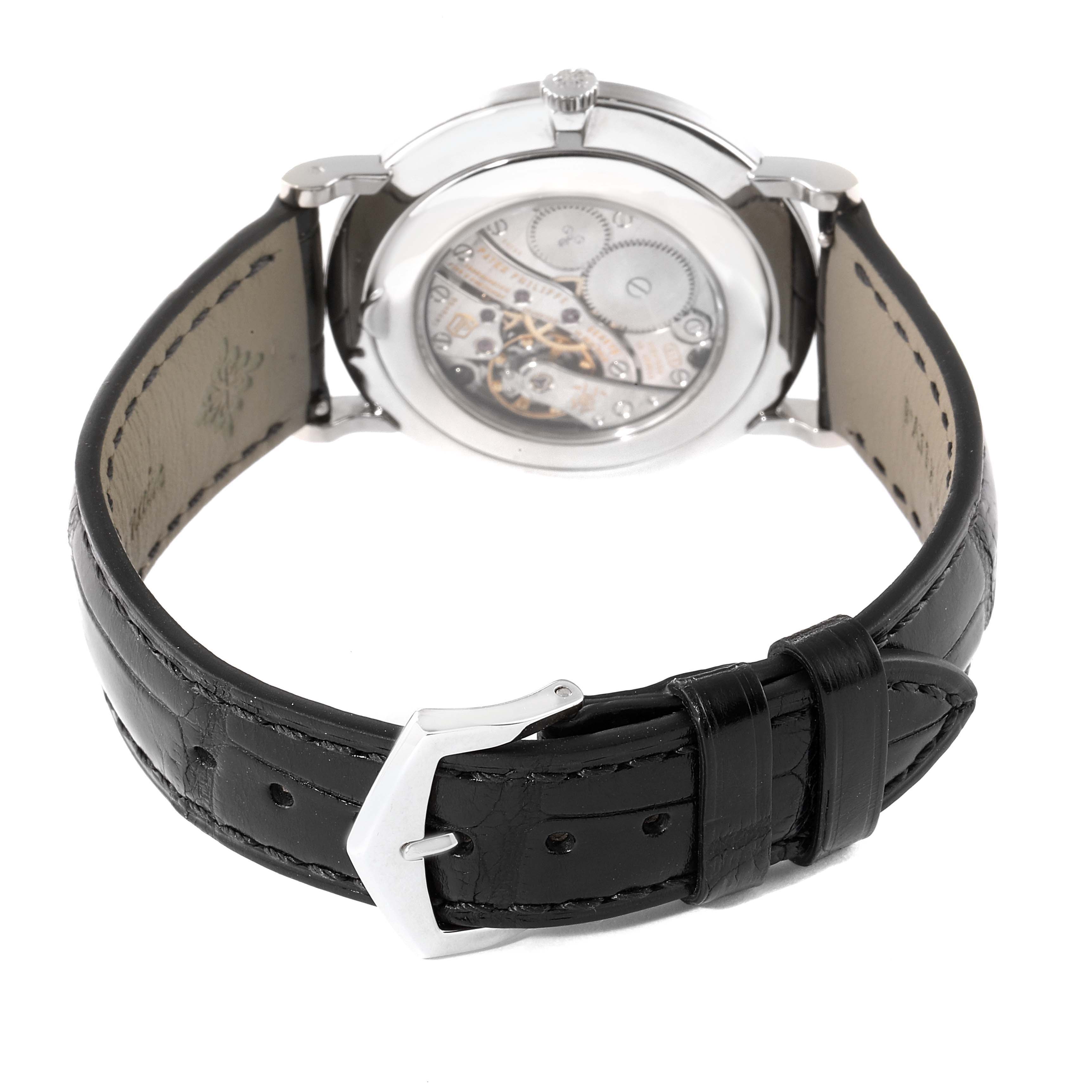 The image shows the back view of a Patek Philippe Calatrava 5119G Men
s White Gold White Dial 5119G Men
s White Gold White Dial watch, highlighting the movement and leather strap with a buckle.