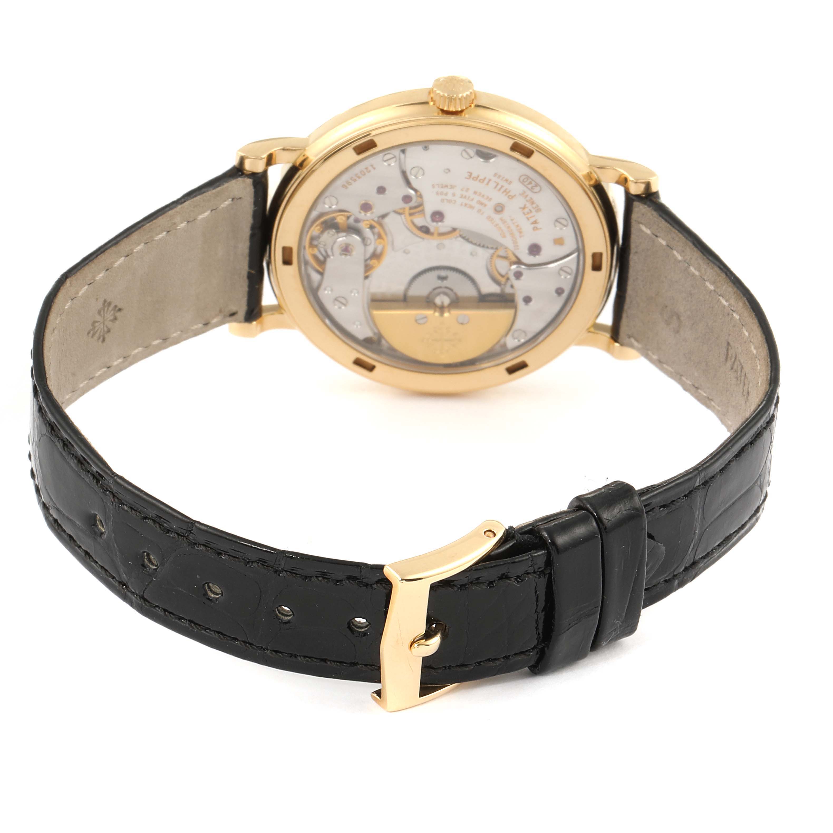 The image shows the back view of a Patek Philippe Calatrava 5120J Men's Yellow Gold White Dial 5120J Men's Yellow Gold White Dial watch, highlighting its movement and leather strap.