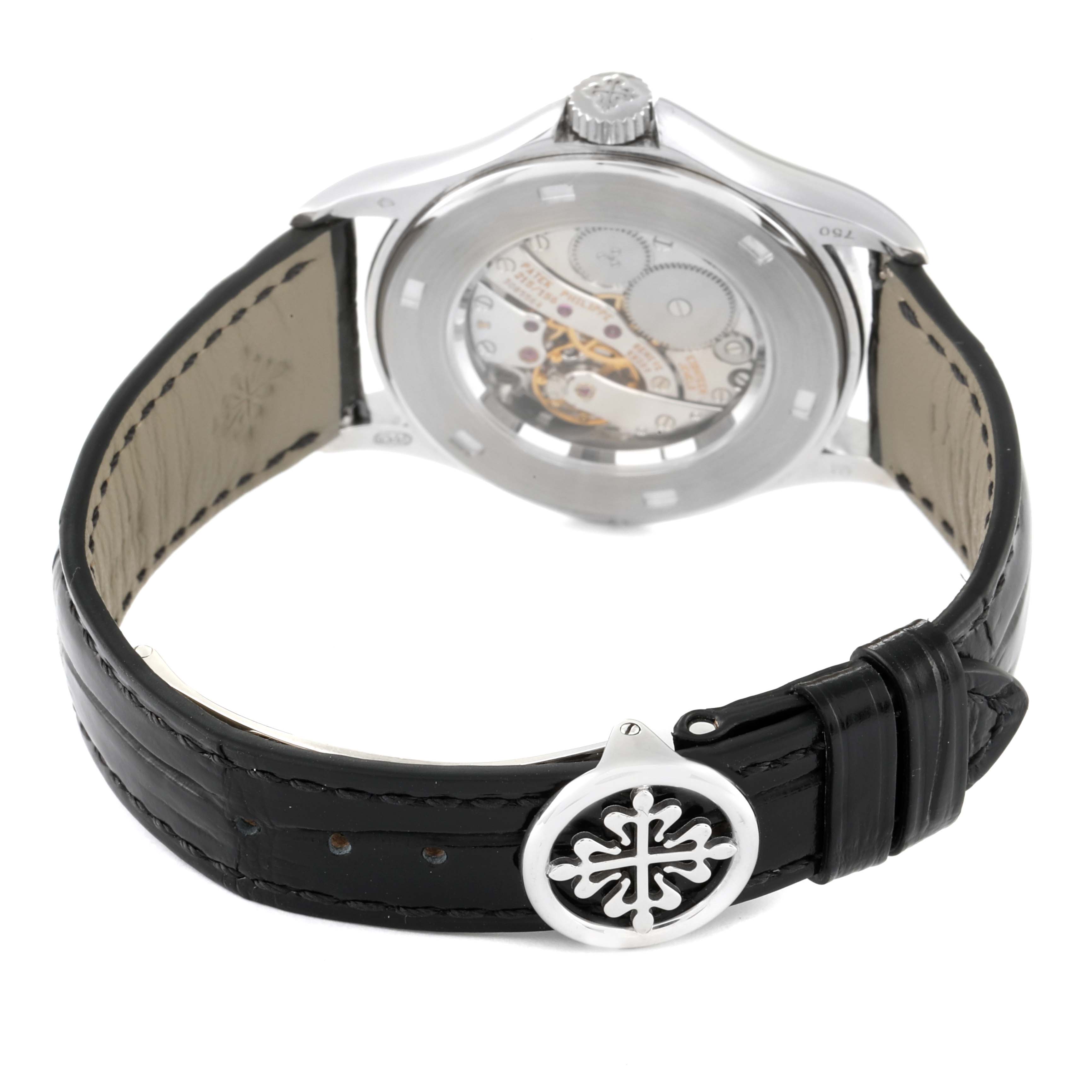 The image shows the back view of a Patek Philippe Calatrava 5134G Men
s White Gold White Dial 5134G Men
s White Gold White Dial watch, highlighting its movement and leather strap.