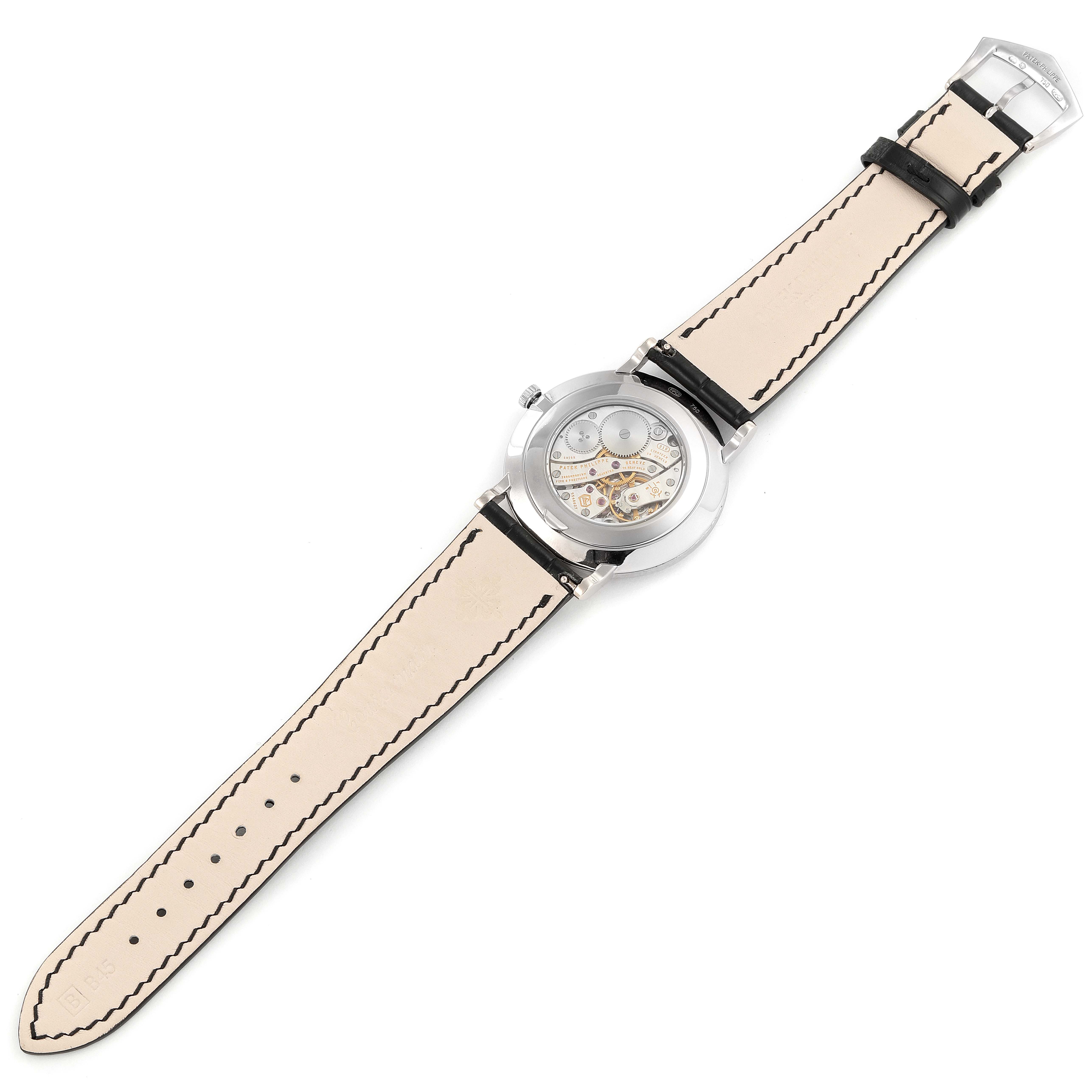 The image shows the back view of a Patek Philippe Calatrava 5116G Men
s White Gold White Dial 5116G Men
s White Gold White Dial watch, displaying its mechanical movement and leather strap.