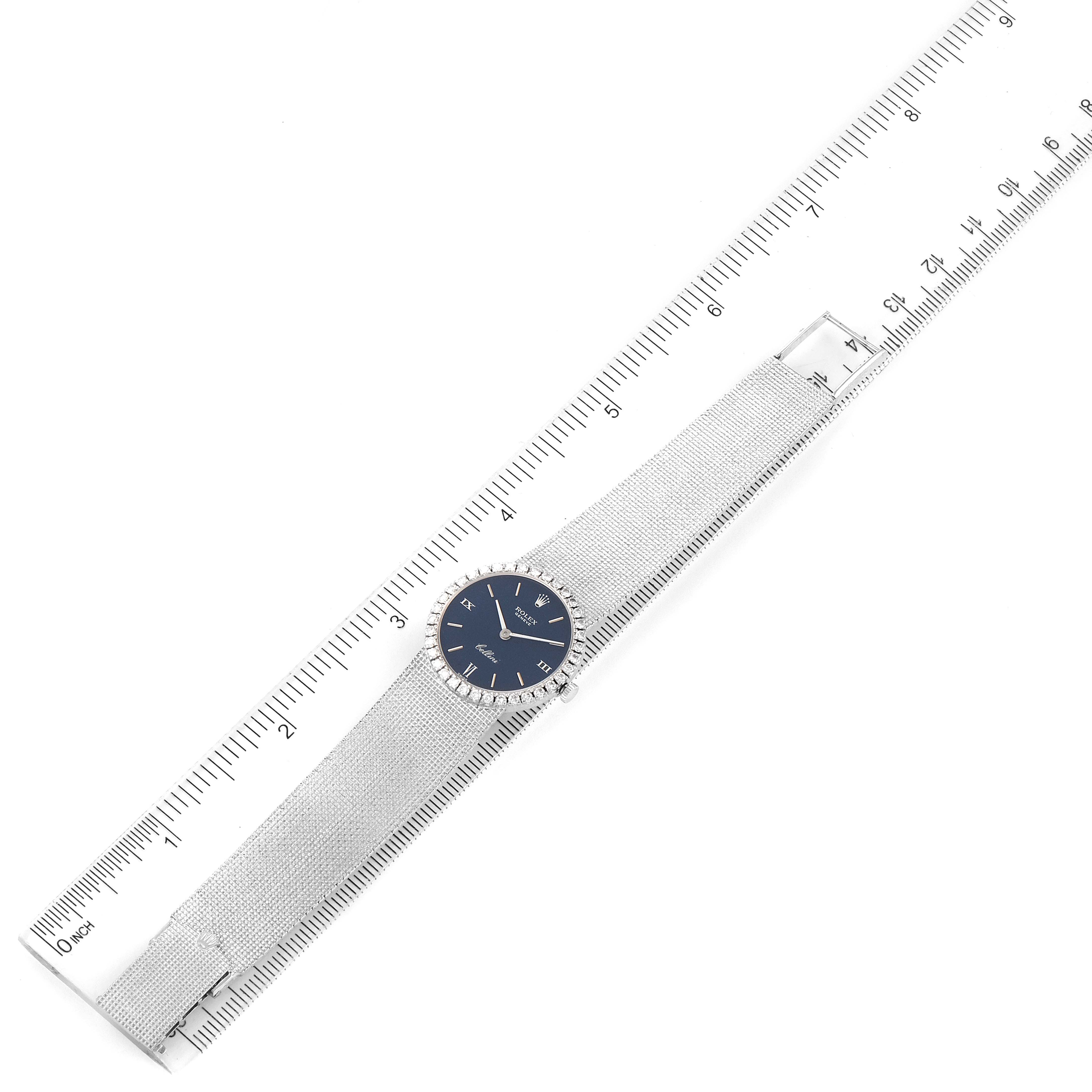 The image shows a top view of a Rolex Cocktail 3812 Women
s White Gold Blue Dial 3812 Women
s White Gold Blue Dial watch with a blue dial and mesh strap, measured against a ruler.