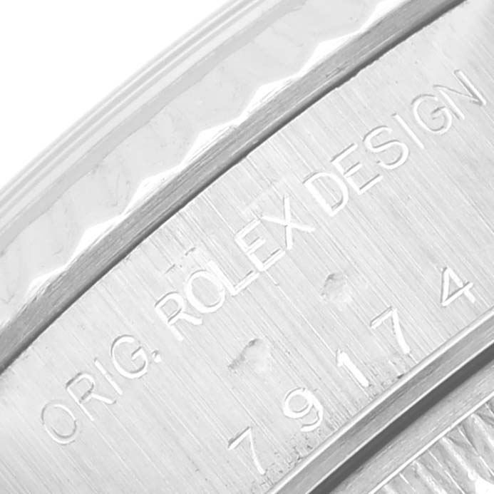 The image shows a close-up of the engraved edge of a Rolex Datejust 79174 Women's Stainless Steel Silver Dial 79174 Women's Stainless Steel Silver Dial watch, displaying the model number and "ORIG. ROLEX DESIGN."