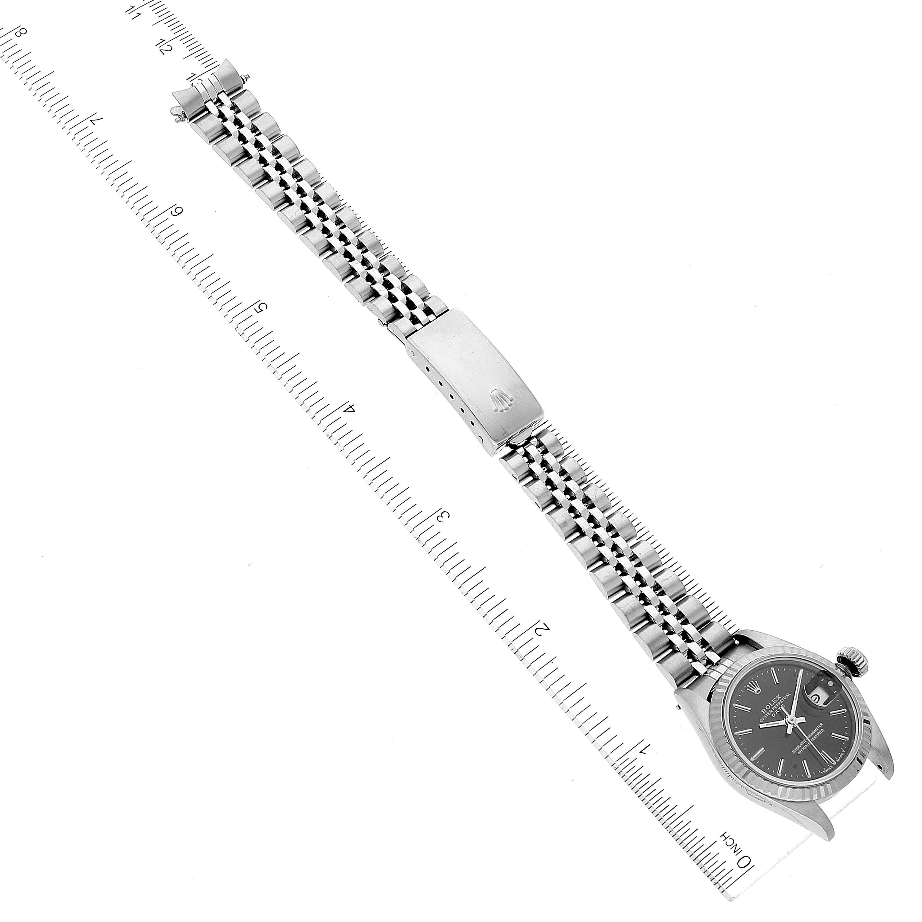 This image shows a Rolex Datejust 69174 Women's Stainless Steel Black Dial 69174 Women's Stainless Steel Black Dial watch laid flat, positioned next to a ruler for size reference.