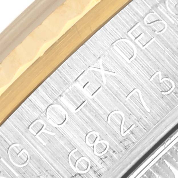 The image shows a close-up of the side of a Rolex Mid-Size 68273 Women's Steel and Gold (two tone) White Dial 68273 Women's Steel and Gold (two tone) White Dial watch case, highlighting engraved text and part of the bezel.