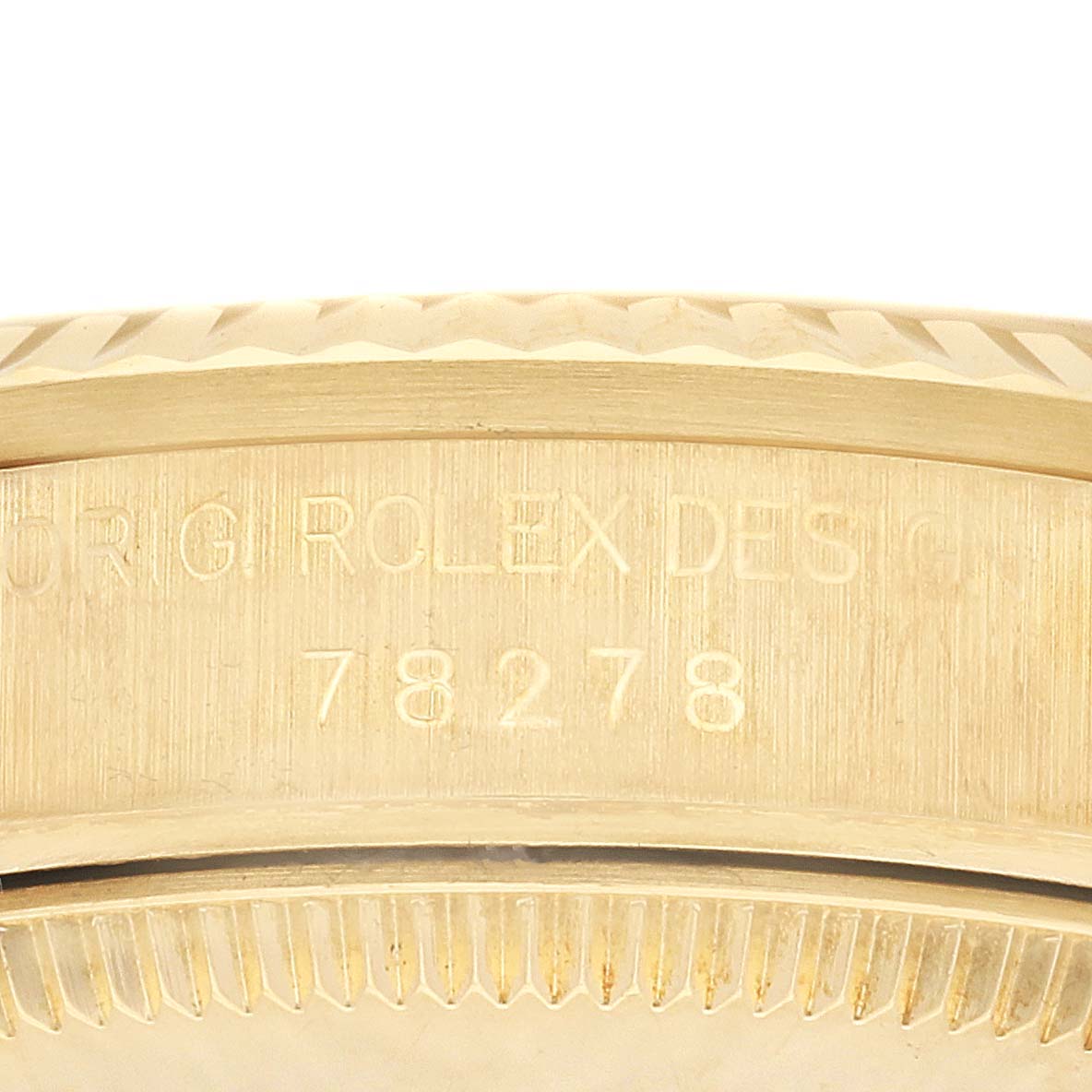 The image shows an angled close-up of the engraved side of a Rolex President 78278 Women's Yellow Gold Champagne Dial 78278 Women's Yellow Gold Champagne Dial model, displaying part of the case and bezel.