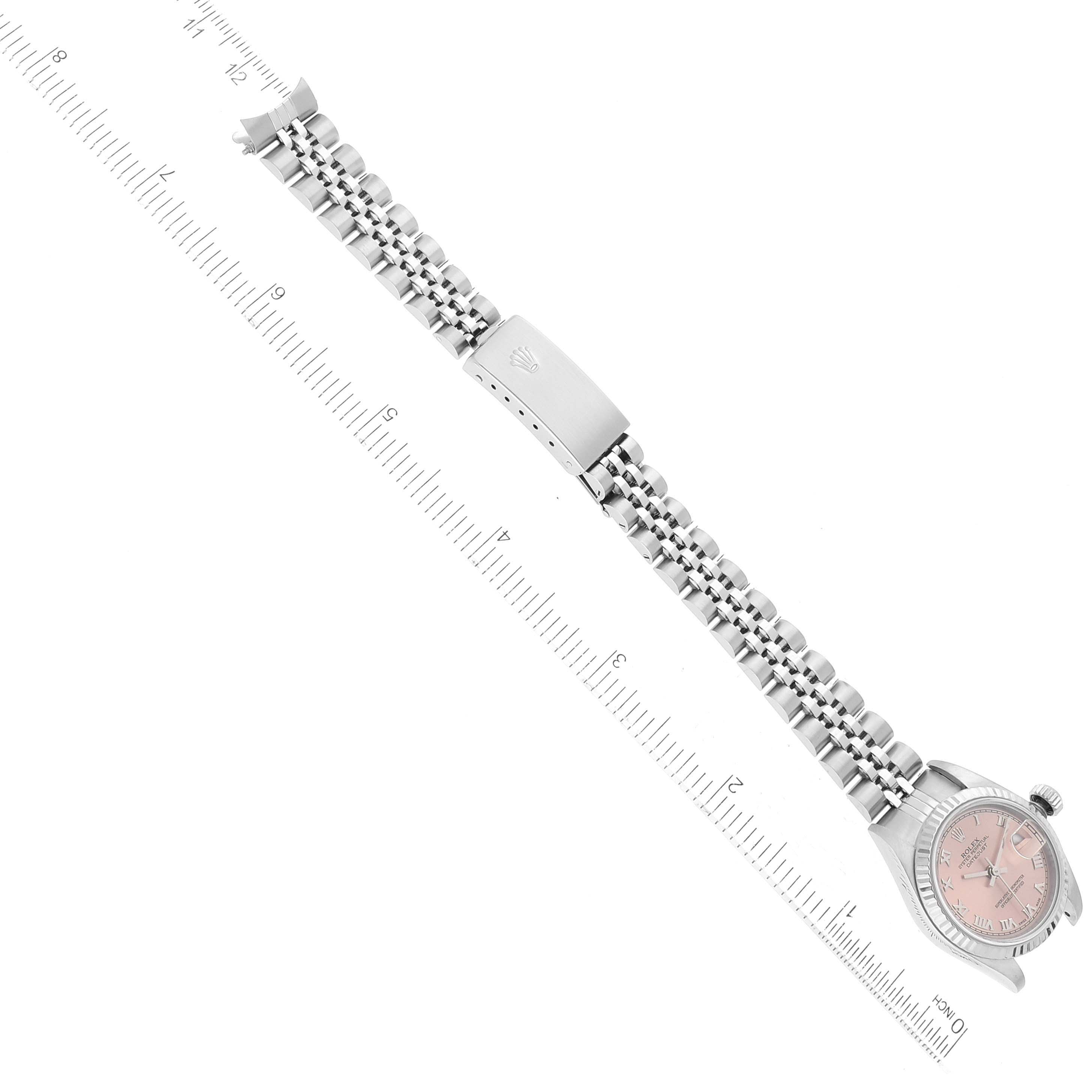 The image shows a Rolex Datejust 79174 Women's Stainless Steel Pink Dial 79174 Women's Stainless Steel Pink Dial watch horizontally aligned with a ruler, displaying its bracelet and clasp.