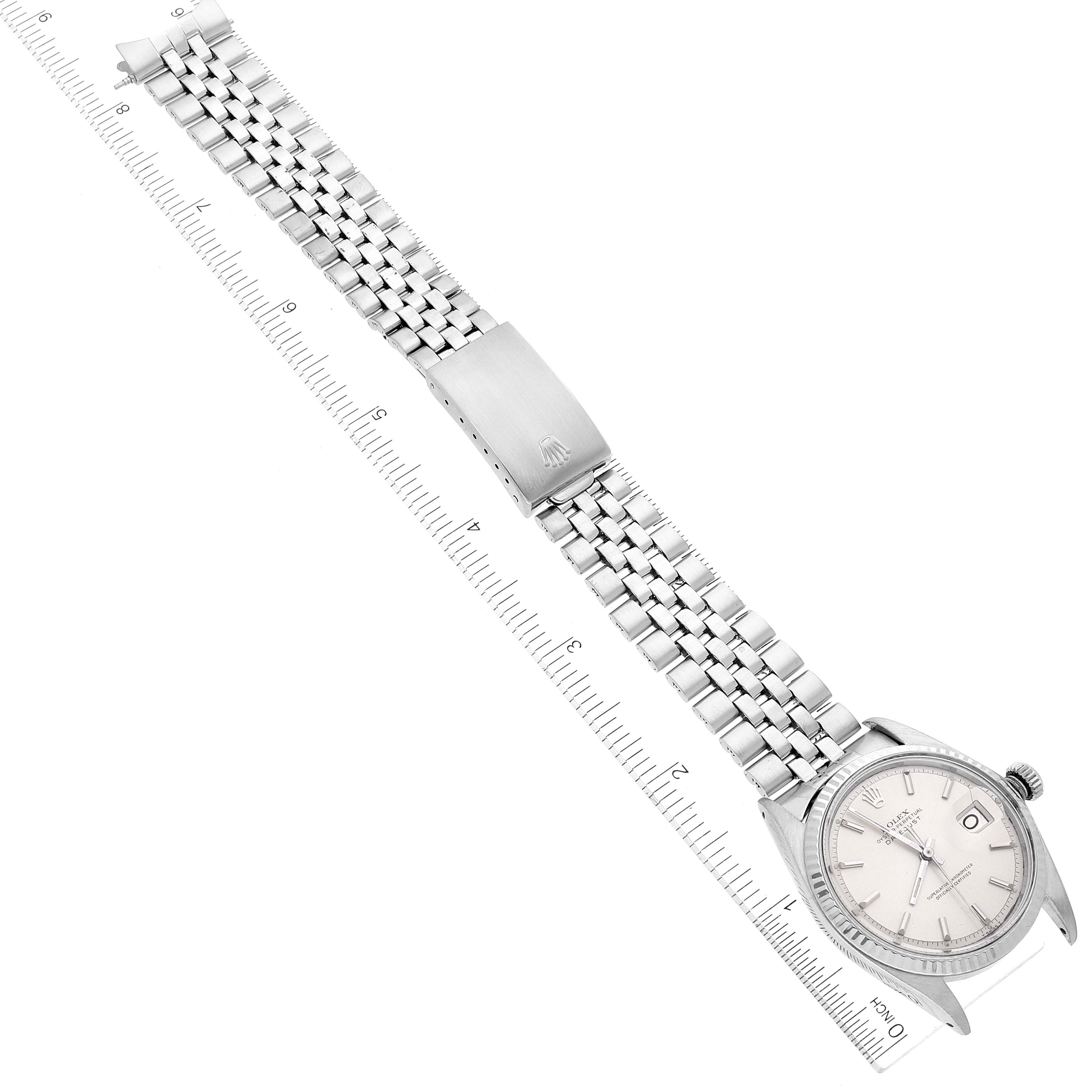 The image displays a Rolex Vintage Collection 1601 Men's Stainless Steel Silver Dial 1601 Men's Stainless Steel Silver Dial watch laid flat with its dial, bezel, crown, and bracelet visible, alongside a ruler for scale.