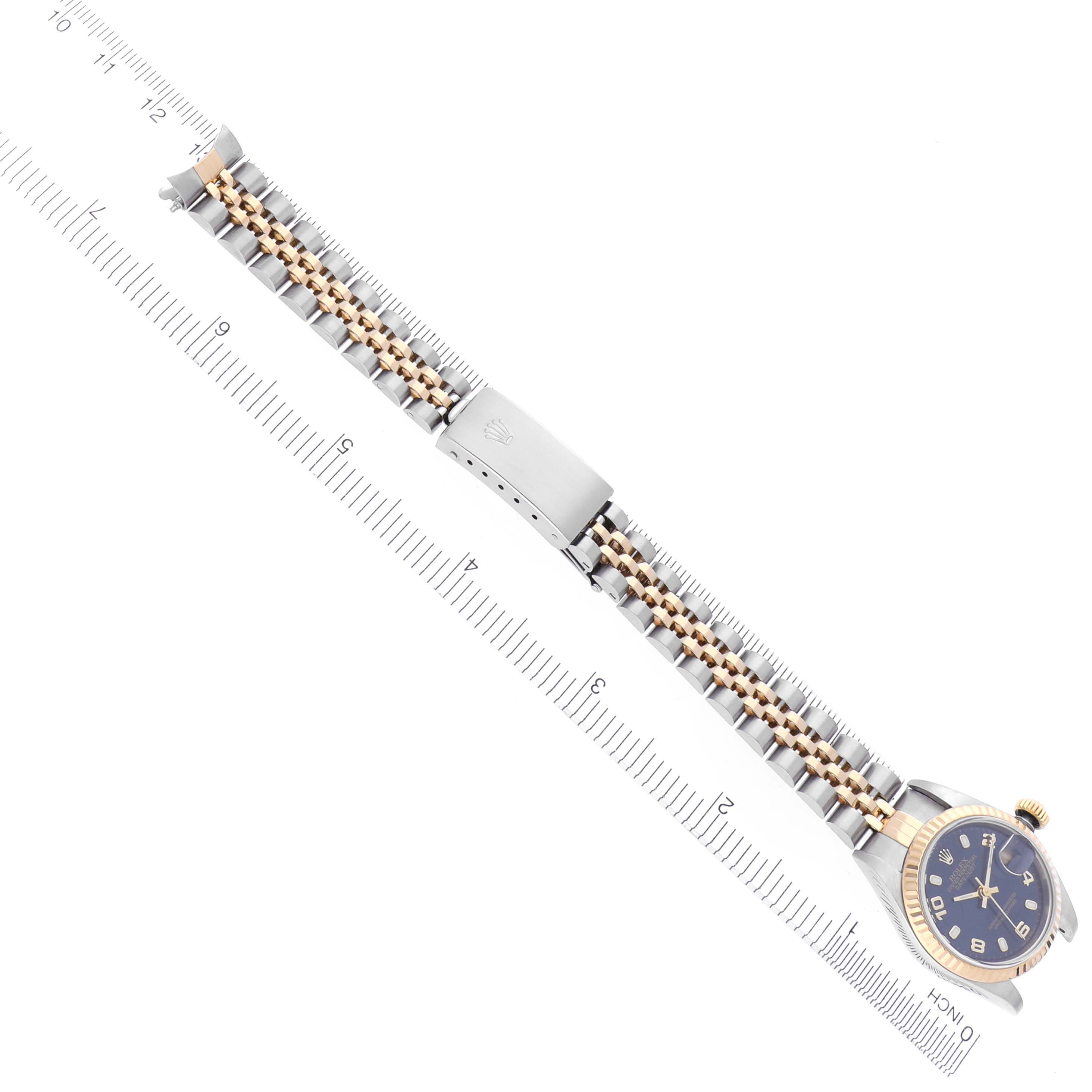 The Rolex Datejust 79173 Women's Steel and Gold (two tone) Blue Dial 79173 Women's Steel and Gold (two tone) Blue Dial watch is shown from a top view, highlighting the bracelet, clasp, and partial face, with a ruler for scale.