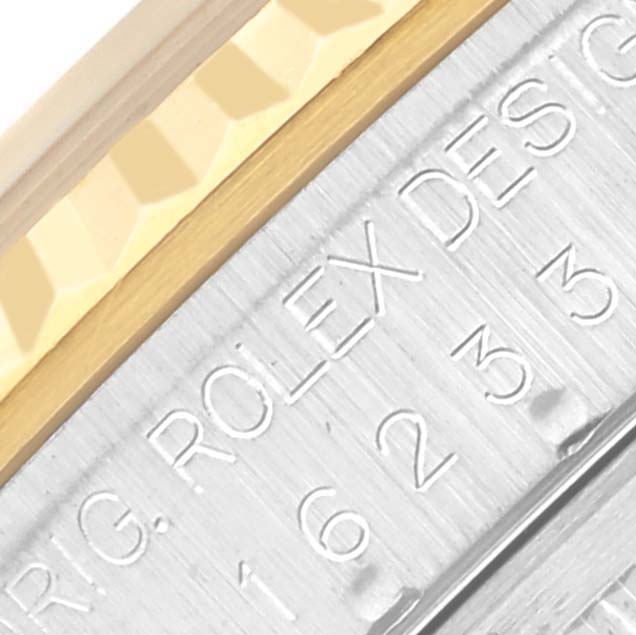 The image shows a close-up of the Rolex Datejust 16233 Men's Steel and Gold (two tone) Beige Dial 16233 Men's Steel and Gold (two tone) Beige Dial's side, highlighting the engraved model details and fluted bezel edge.