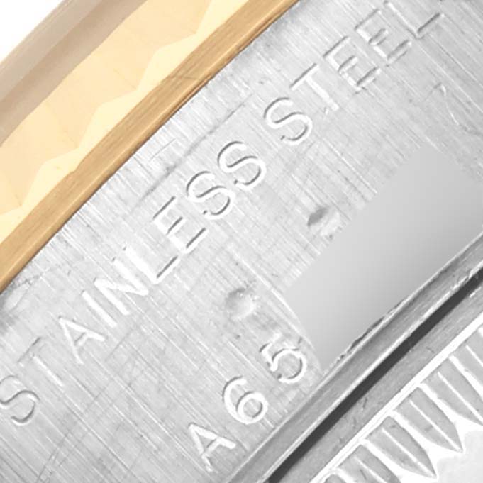 The image shows the edge of a Rolex Datejust 79173 Women's Steel and Gold (two tone) White Dial 79173 Women's Steel and Gold (two tone) White Dial case, highlighting the "STAINLESS STEEL" engraving and part of the bezel.