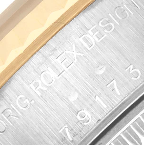 The image shows a close-up of the side of a Rolex Datejust 79173 Women's Steel and Gold (two tone) White Dial 79173 Women's Steel and Gold (two tone) White Dial, focusing on the engraved bezel and case edge.