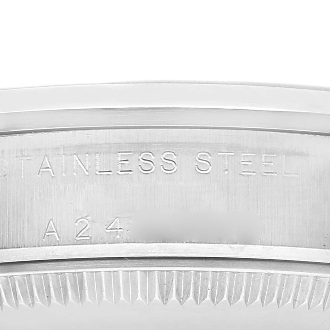 The image shows a close-up view of the stainless steel case back of a Mid-Size Rolex watch, highlighting part of the serial number and material.