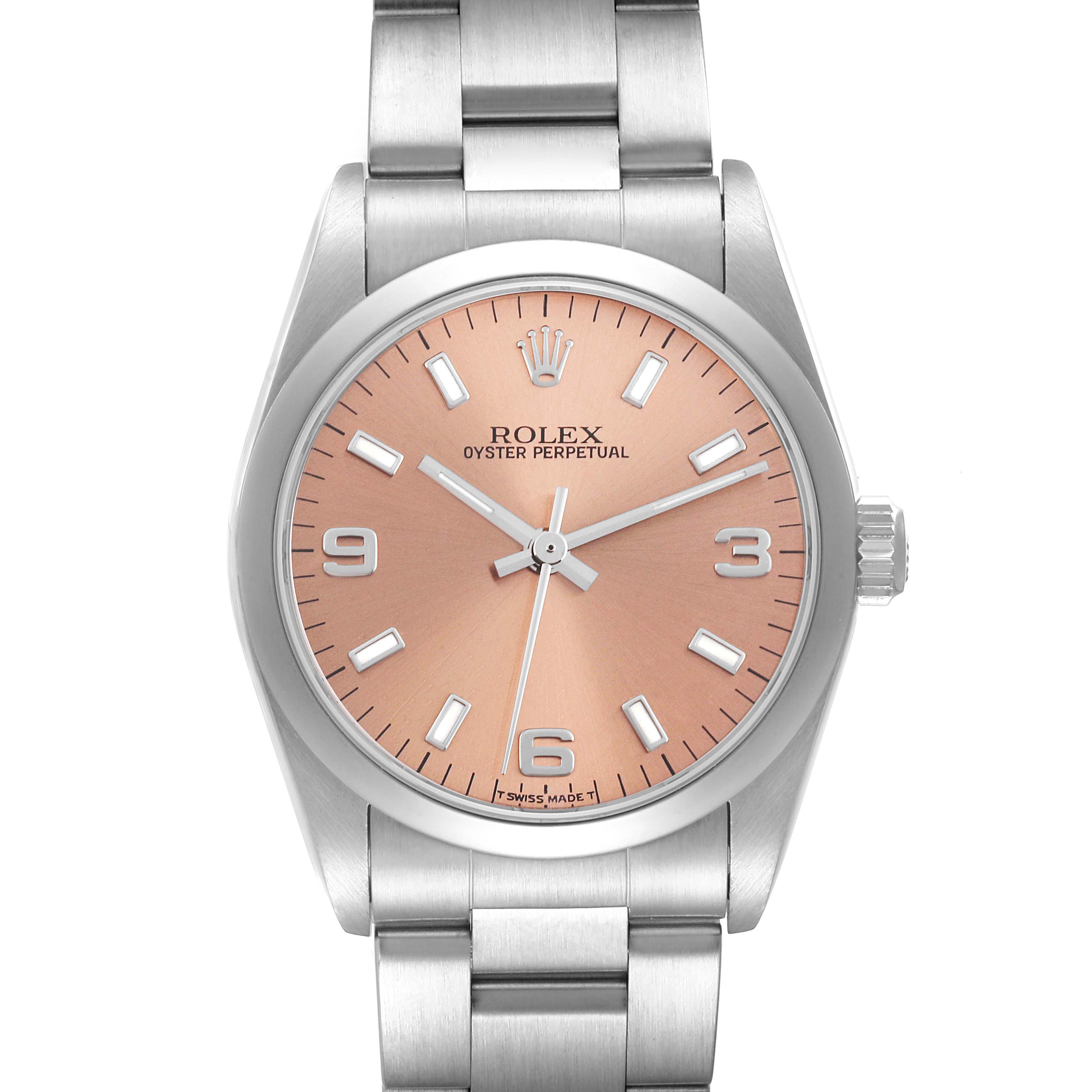 The Mid-Size Rolex Oyster Perpetual watch is shown from a front angle, highlighting its peach dial and stainless steel bracelet.