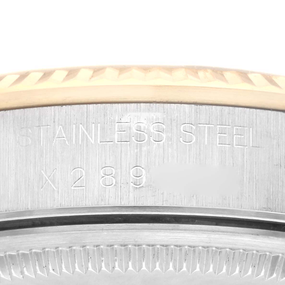 This image shows a close-up angle of the side of a Rolex Oyster Perpetual 14233 Men's Steel and Gold (two tone) Silver Dial 14233 Men's Steel and Gold (two tone) Silver Dial watch, focusing on the stainless steel case with engraved text.