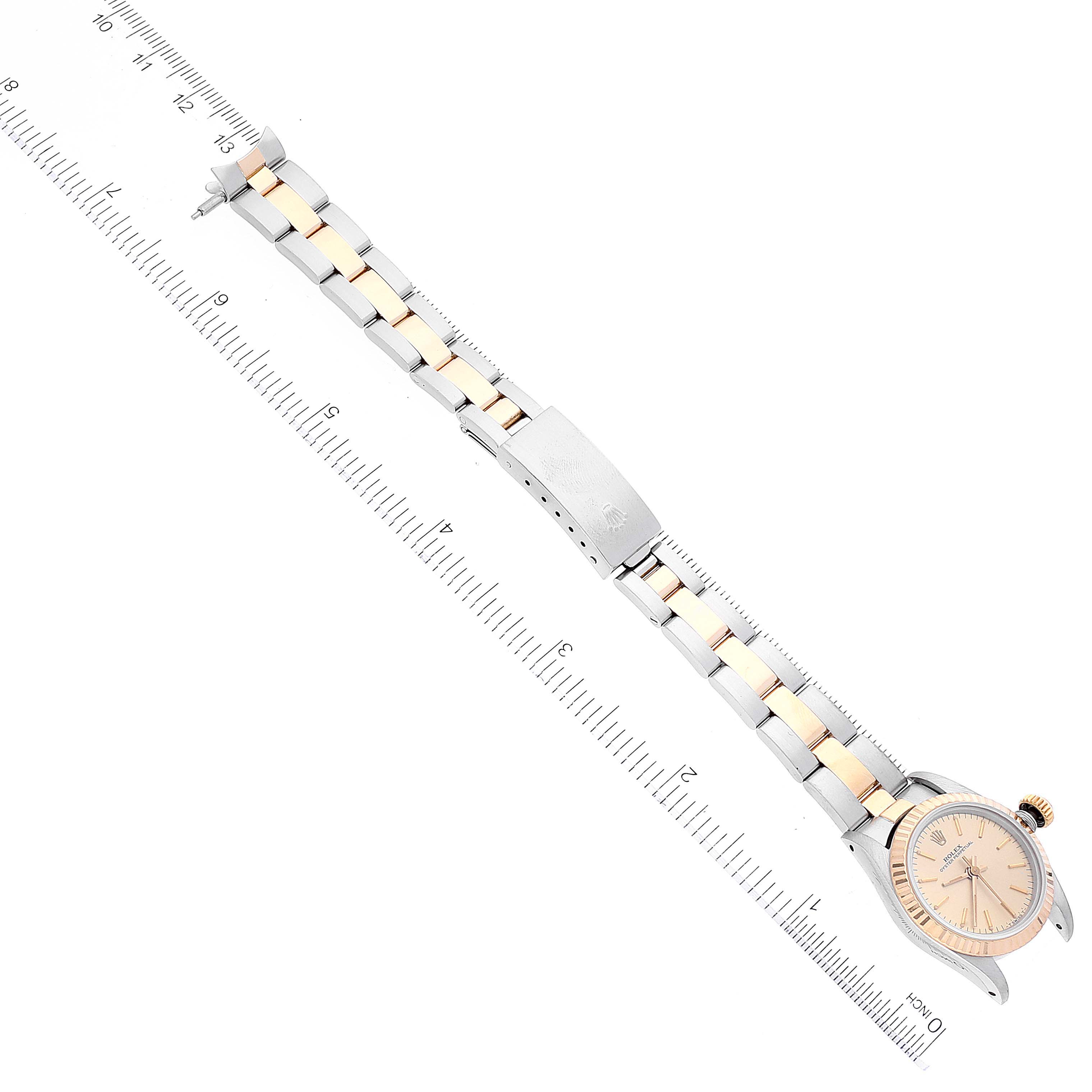 This image shows the full length of a Rolex Oyster Perpetual 67193 Women's Steel and Gold (two tone) Champagne Dial 67193 Women's Steel and Gold (two tone) Champagne Dial watch from a top-down view, including the dial and bracelet.