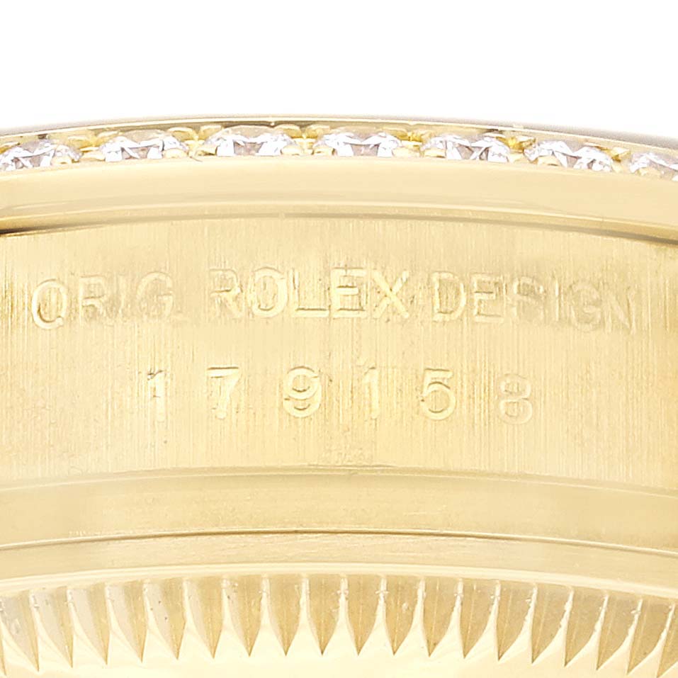 The image shows the side profile of a Rolex President 179158 Women's Yellow Gold Champagne Dial 179158 Women's Yellow Gold Champagne Dial model, focusing on the engraved bezel and diamond-set upper edge.