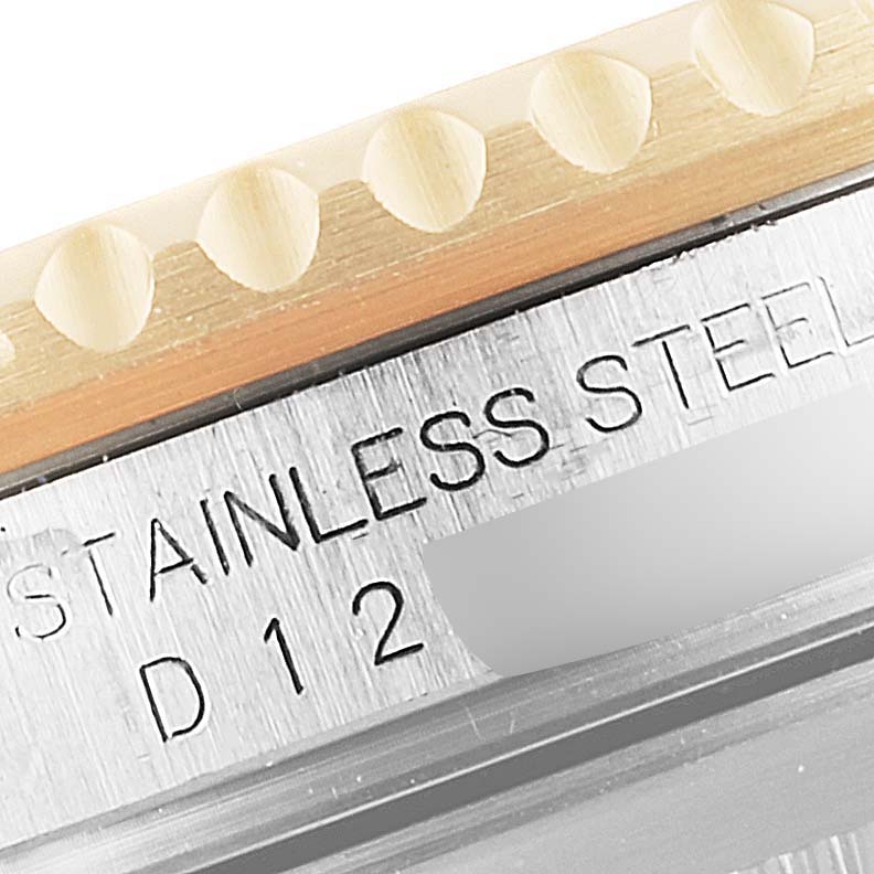 This image shows a close-up of the side of the bezel and case for a Rolex Submariner 16613 Men's Steel and Gold (two tone) Blue Dial 16613 Men's Steel and Gold (two tone) Blue Dial, highlighting the "STAINLESS STEEL" engraving.