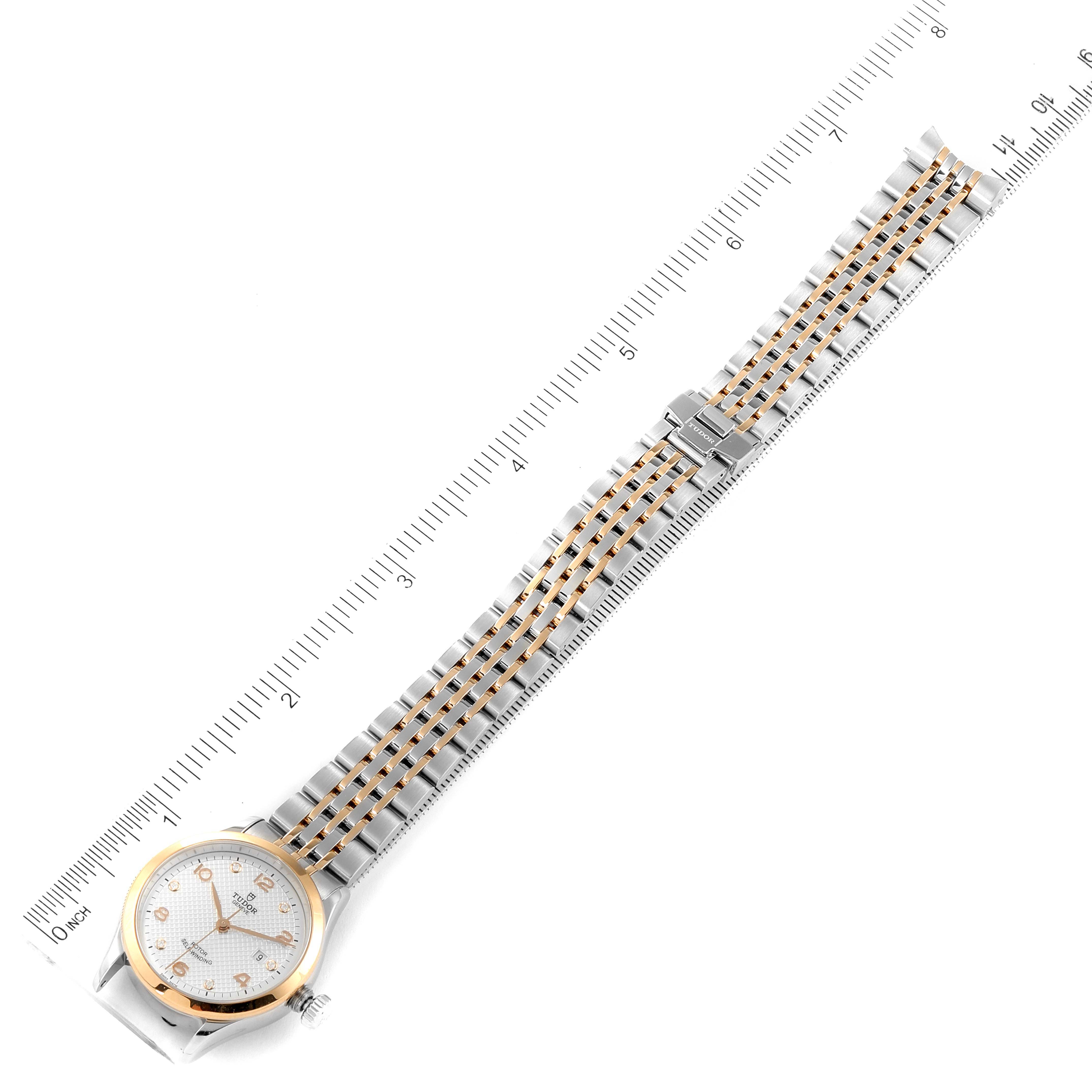 The image shows a Tudor M91351-002 Women's Steel and Gold (two tone) Silver Dial M91351-002 Women's Steel and Gold (two tone) Silver Dial 1926 28mm Steel Rose Gold Silver Dial Diamond Watch M91351 laid flat with a ruler for scale.