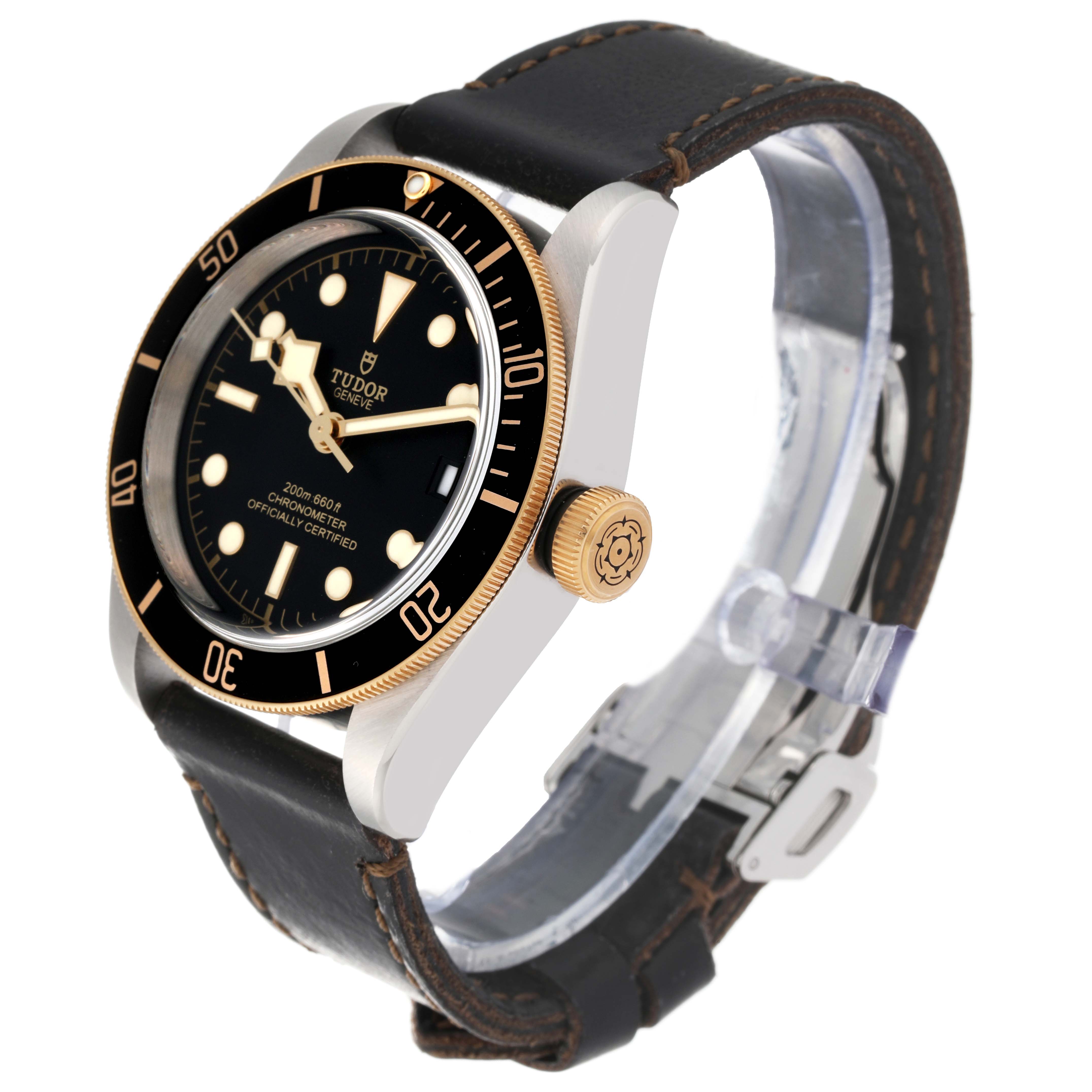 The Tudor Heritage Black Bay 79733N Men
s Steel and Gold (two tone) Black Dial 79733N Men
s Steel and Gold (two tone) Black Dial watch is shown at a front-side angle, highlighting its bezel, dial, crown, and leather strap.