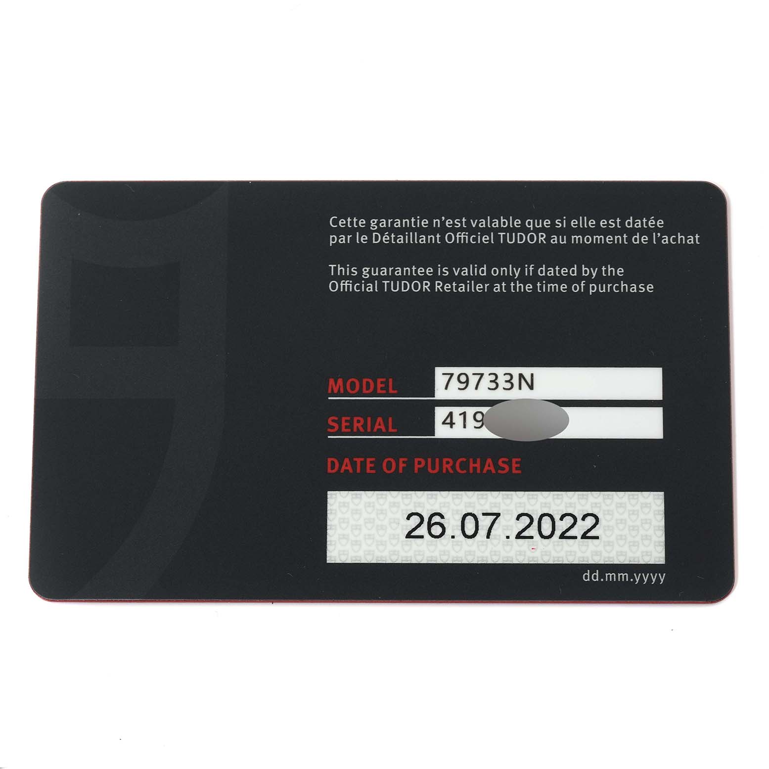 This image shows a guarantee card for the Tudor Heritage Black Bay 79733N Men
s Steel and Gold (two tone) Black Dial 79733N Men
s Steel and Gold (two tone) Black Dial model 79733N, with purchase date and partially obscured serial number.