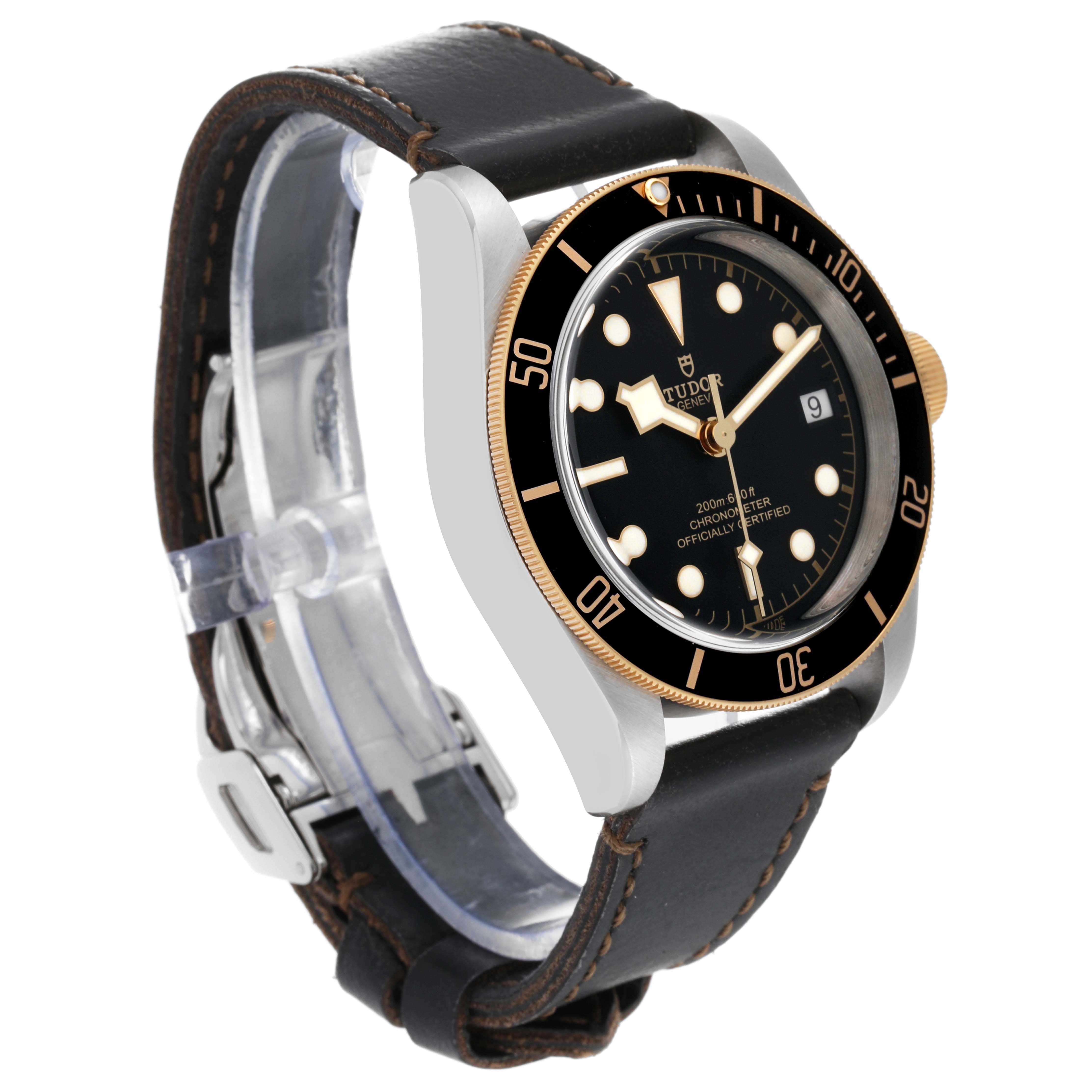This image shows a Tudor Heritage Black Bay 79733N Men
s Steel and Gold (two tone) Black Dial 79733N Men
s Steel and Gold (two tone) Black Dial watch at a three-quarter angle, highlighting its dial, bezel, and leather strap.