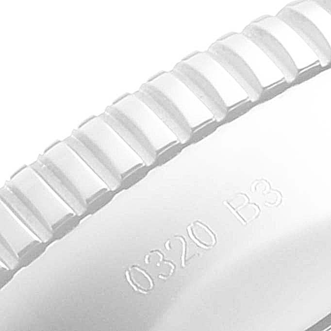 The image shows a close-up of the ridged crown of a Breitling Superocean A17321 Men's Stainless Steel Blue Dial A17321 Men's Stainless Steel Blue Dial watch, with partial text engraving visible.