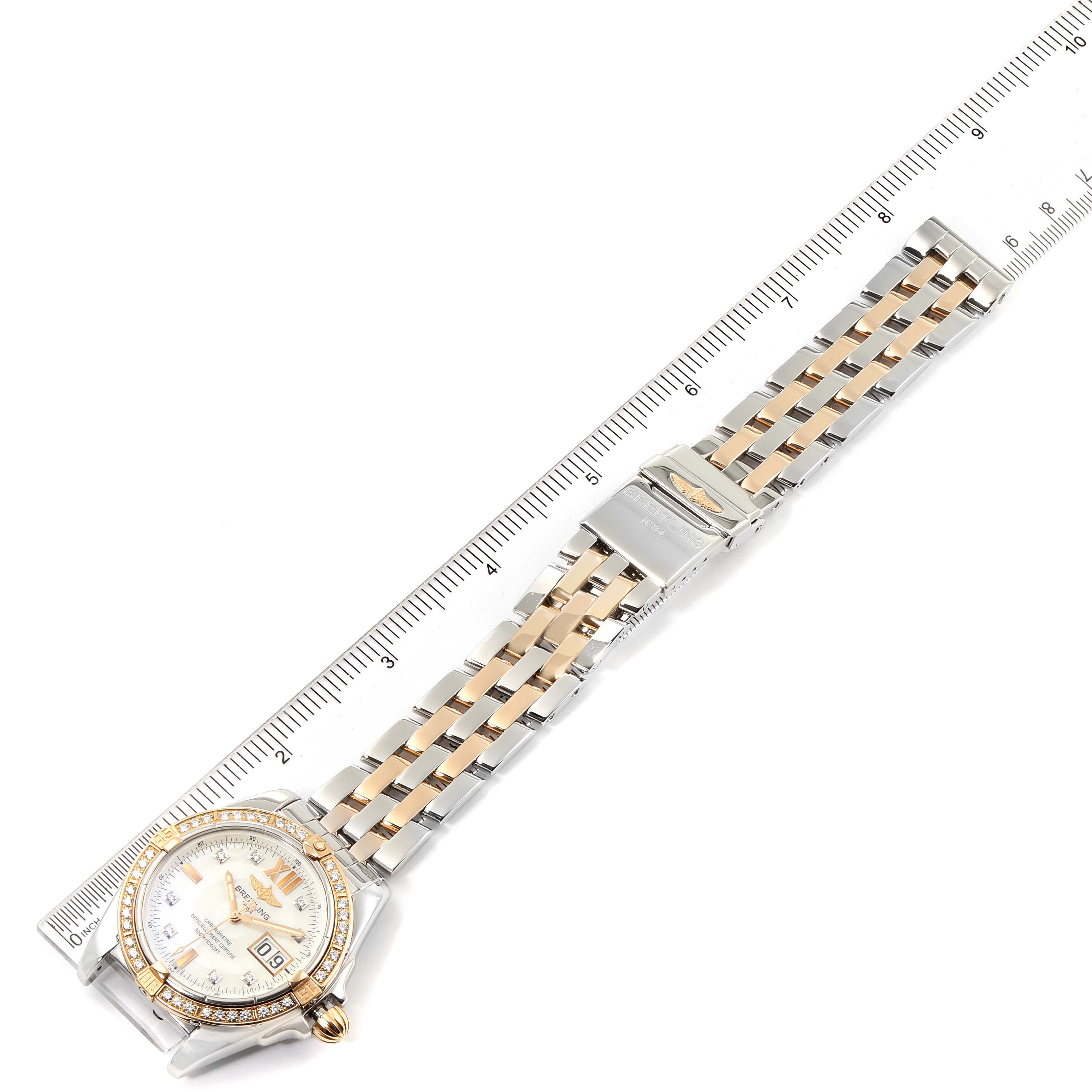 The image shows a Breitling Windrider C49350 Men's Steel and Gold (two tone) Mother of Pearl Dial C49350 Men's Steel and Gold (two tone) Mother of Pearl Dial watch laid flat with a ruler for scale, displaying the band and face.