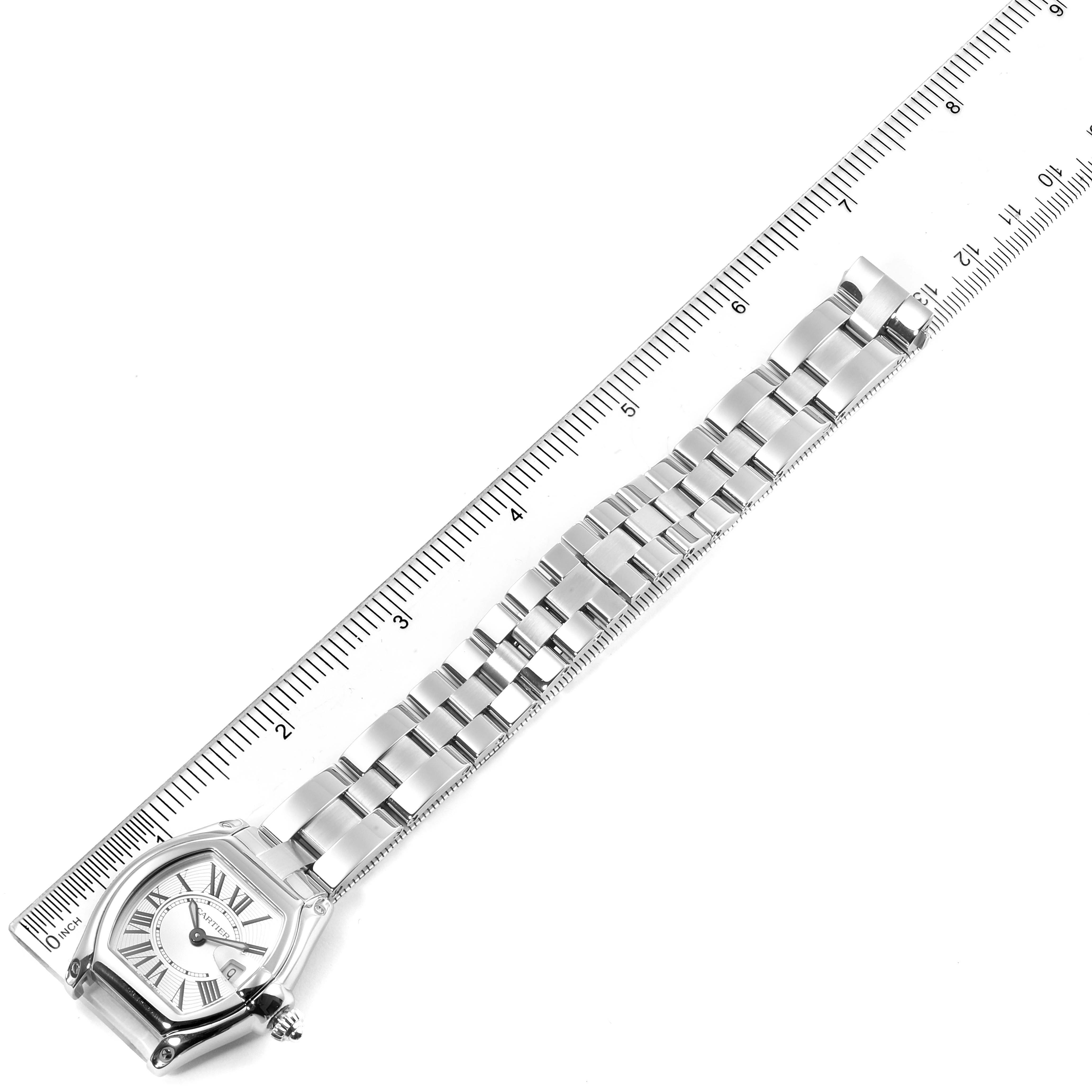 The image shows a top-down view of the Cartier Roadster W62016V3 Women's Stainless Steel Silver Dial W62016V3 Women's Stainless Steel Silver Dial watch and its metal bracelet along with a ruler for scale.