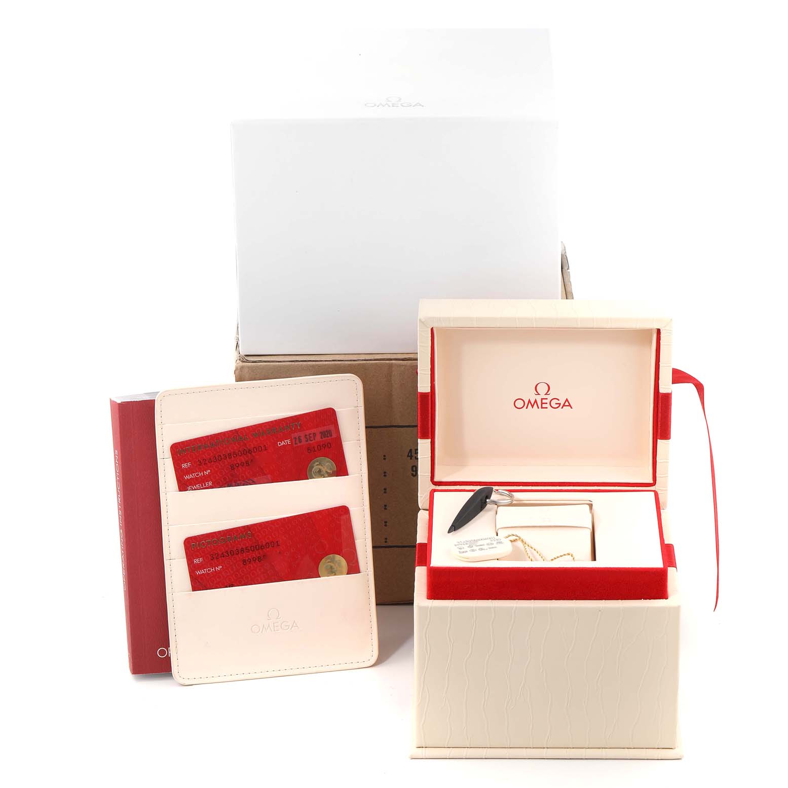 The image shows the packaging and accessories of an Omega Speedmaster 324.30.38.50.06.001 Men
s Stainless Steel Grey Dial 324.30.38.50.06.001 Men
s Stainless Steel Grey Dial watch, including the watch box and warranty cards.