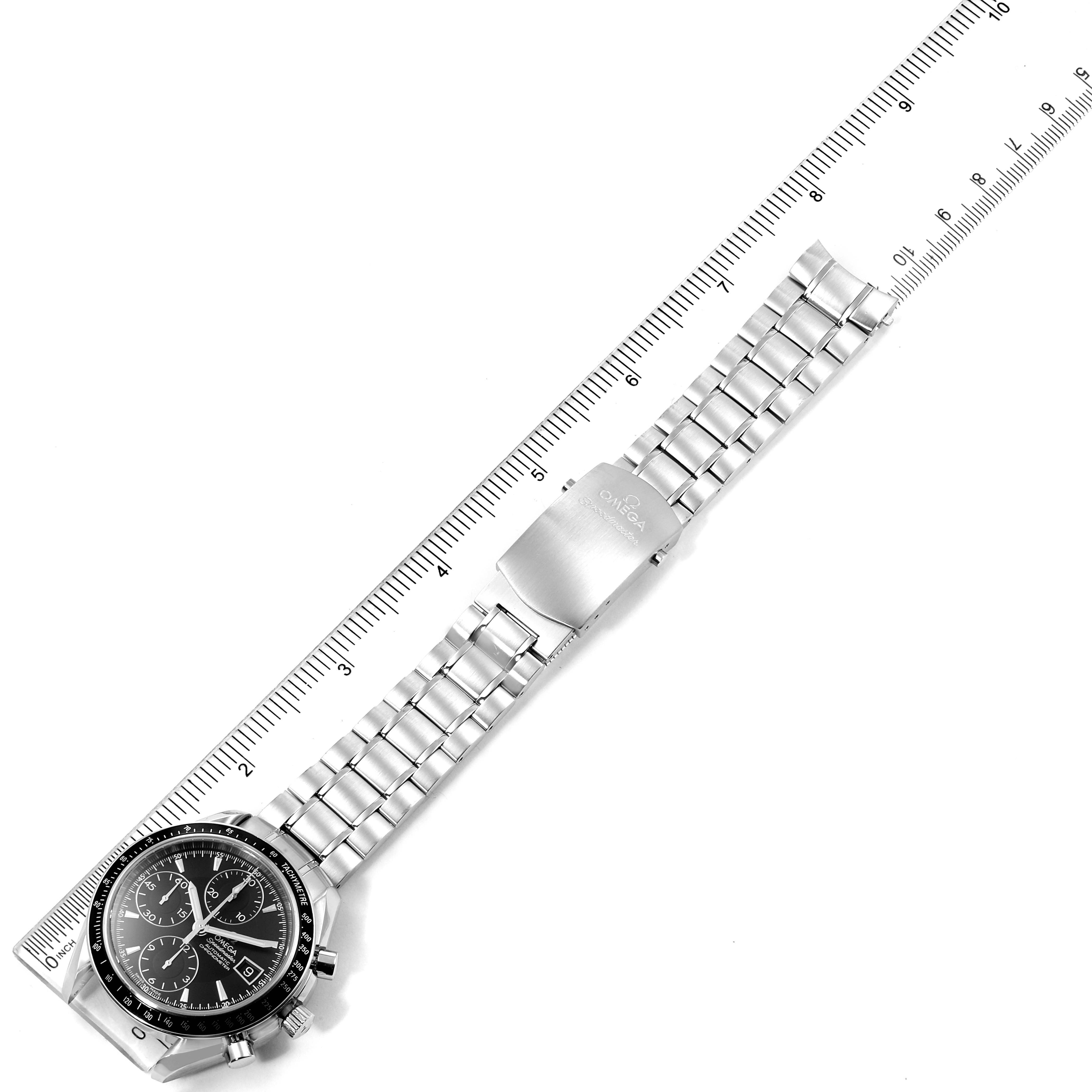 The image shows an overhead view of an Omega Speedmaster 3210.50.0031391 Men
s Stainless Steel Black Dial 3210.50.0031391 Men
s Stainless Steel Black Dial watch laid out flat alongside a ruler.