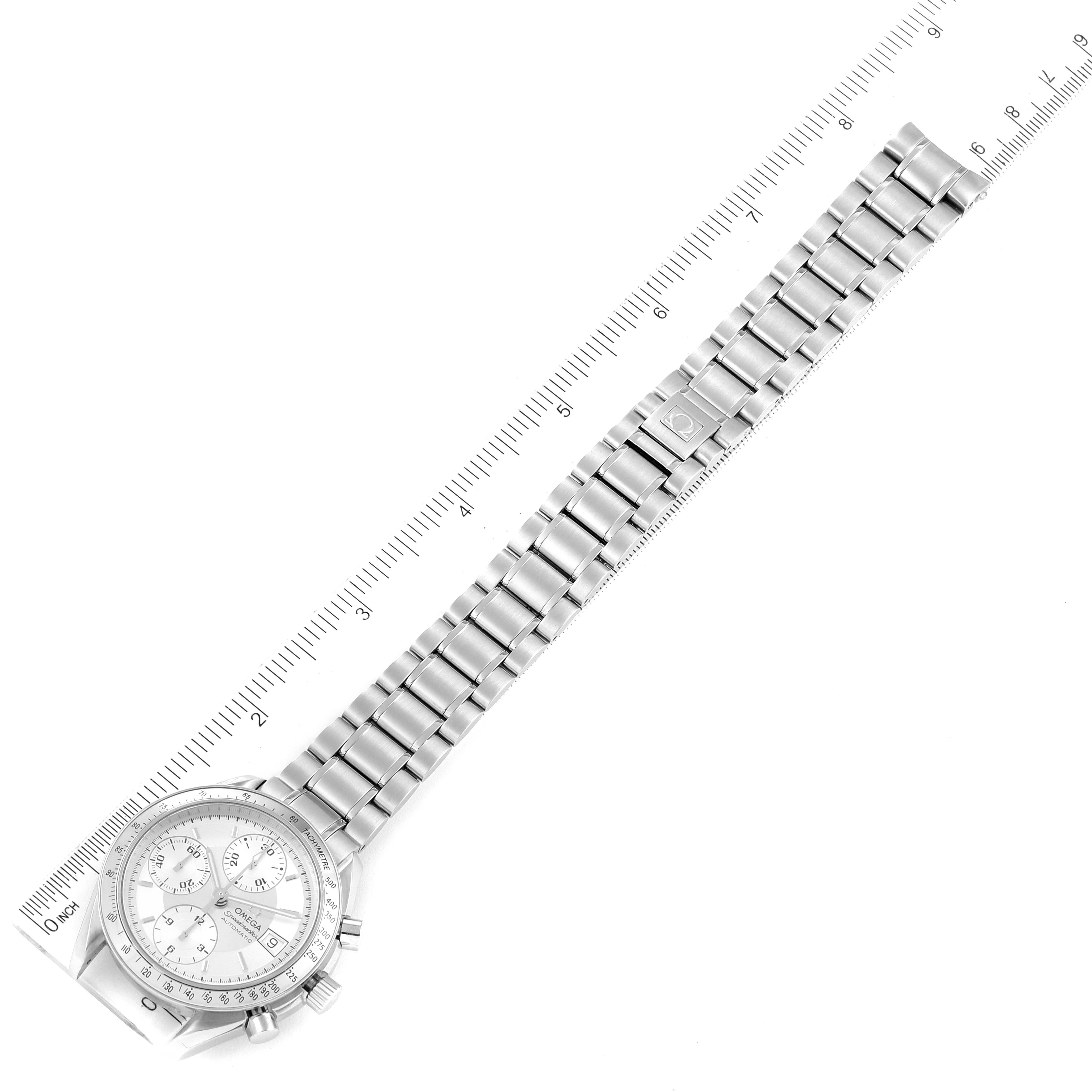 The image shows an overhead view of an Omega Speedmaster 3513.30.00 Men
s Stainless Steel Silver Dial 3513.30.00 Men
s Stainless Steel Silver Dial watch laid flat next to a ruler for scale.