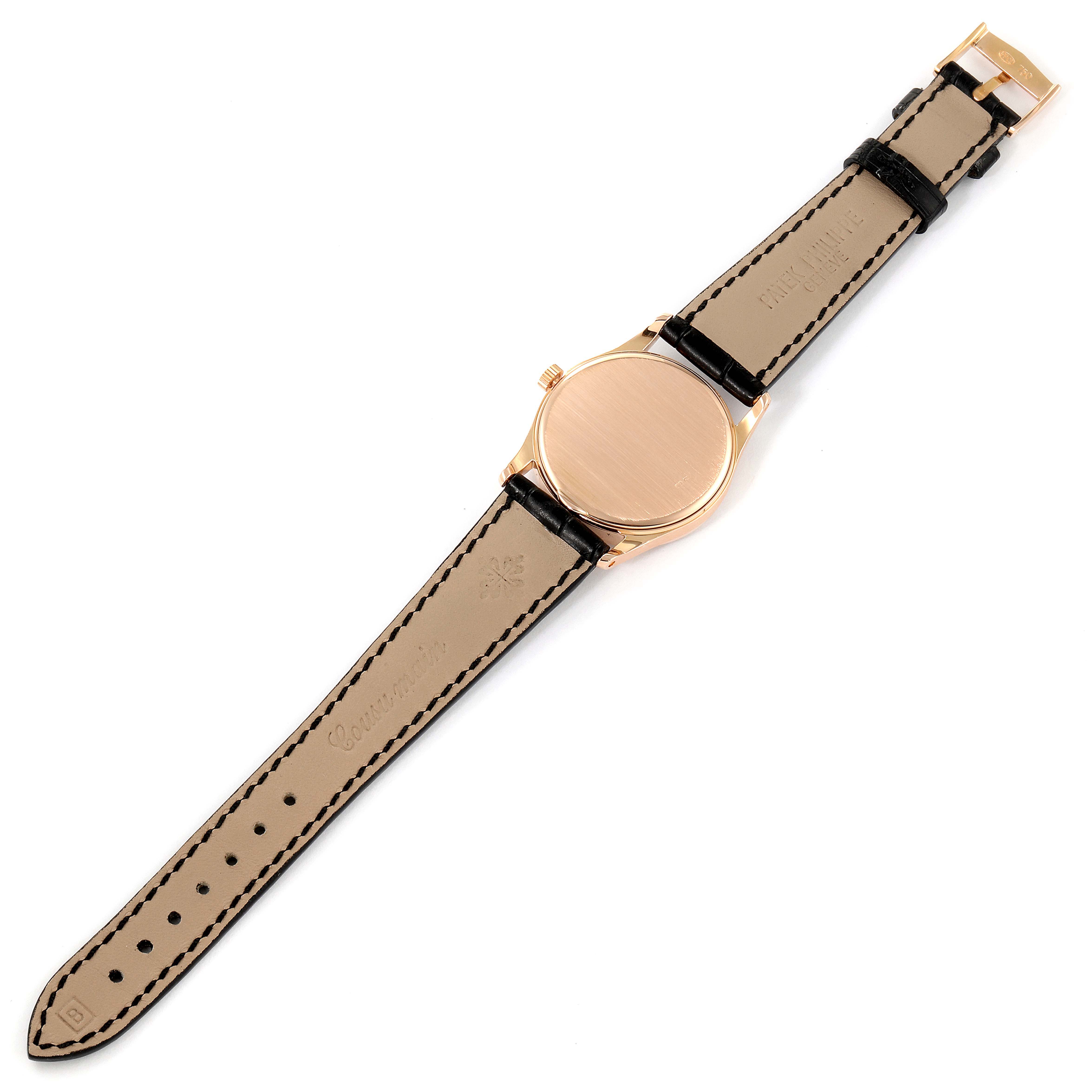 The image shows the back view of a Patek Philippe Calatrava 3796R Men
s Rose Gold Silver Dial 3796R Men
s Rose Gold Silver Dial watch with a gold case and leather strap.