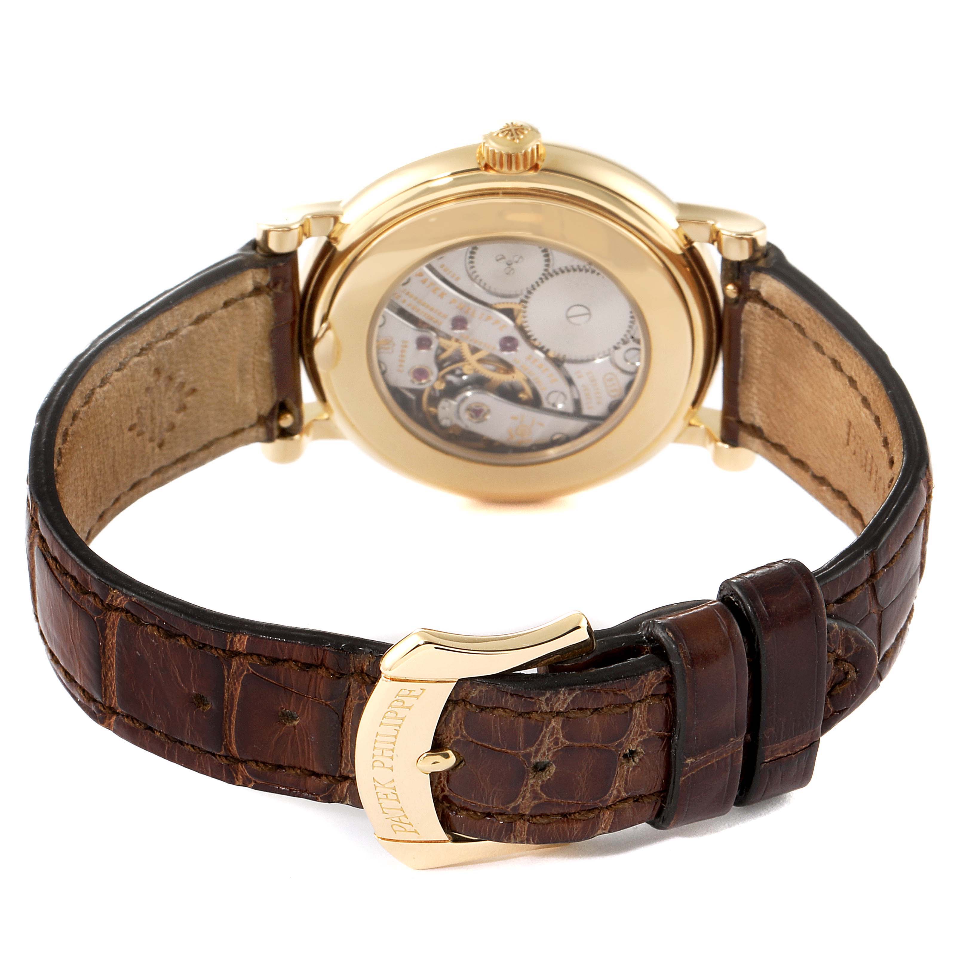 The image shows the back view of a Patek Philippe Calatrava 4959J Women's Yellow Gold Mother of Pearl Dial 4959J Women's Yellow Gold Mother of Pearl Dial watch, highlighting the movement and leather strap with a gold clasp.