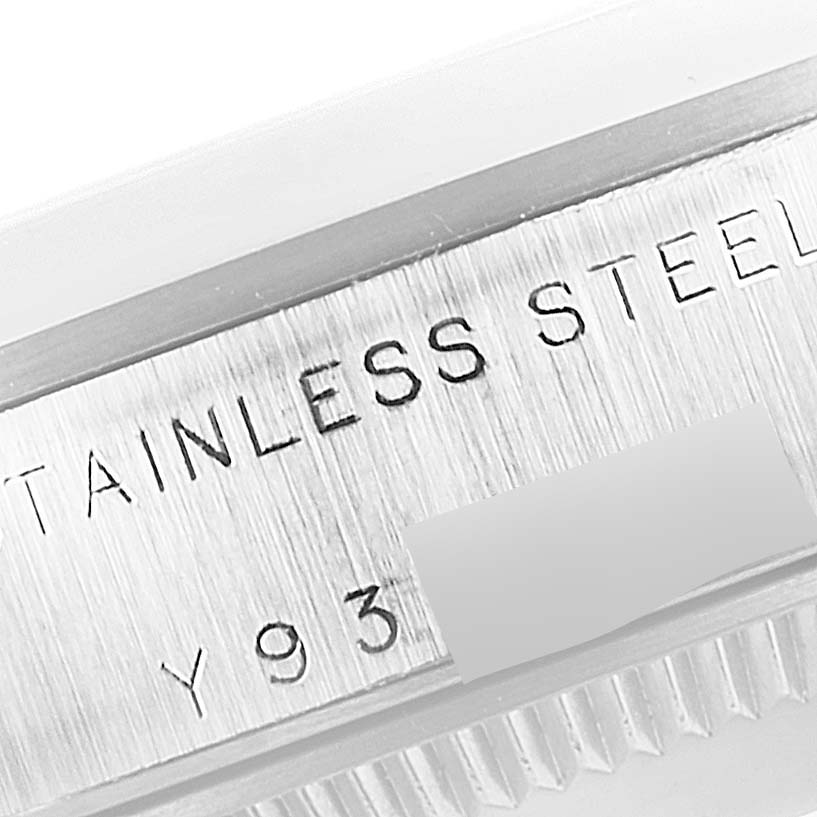 A close-up of the side engraving on the Mid-Size Rolex watch case band displaying "STAINLESS STEEL" and part of the serial number.