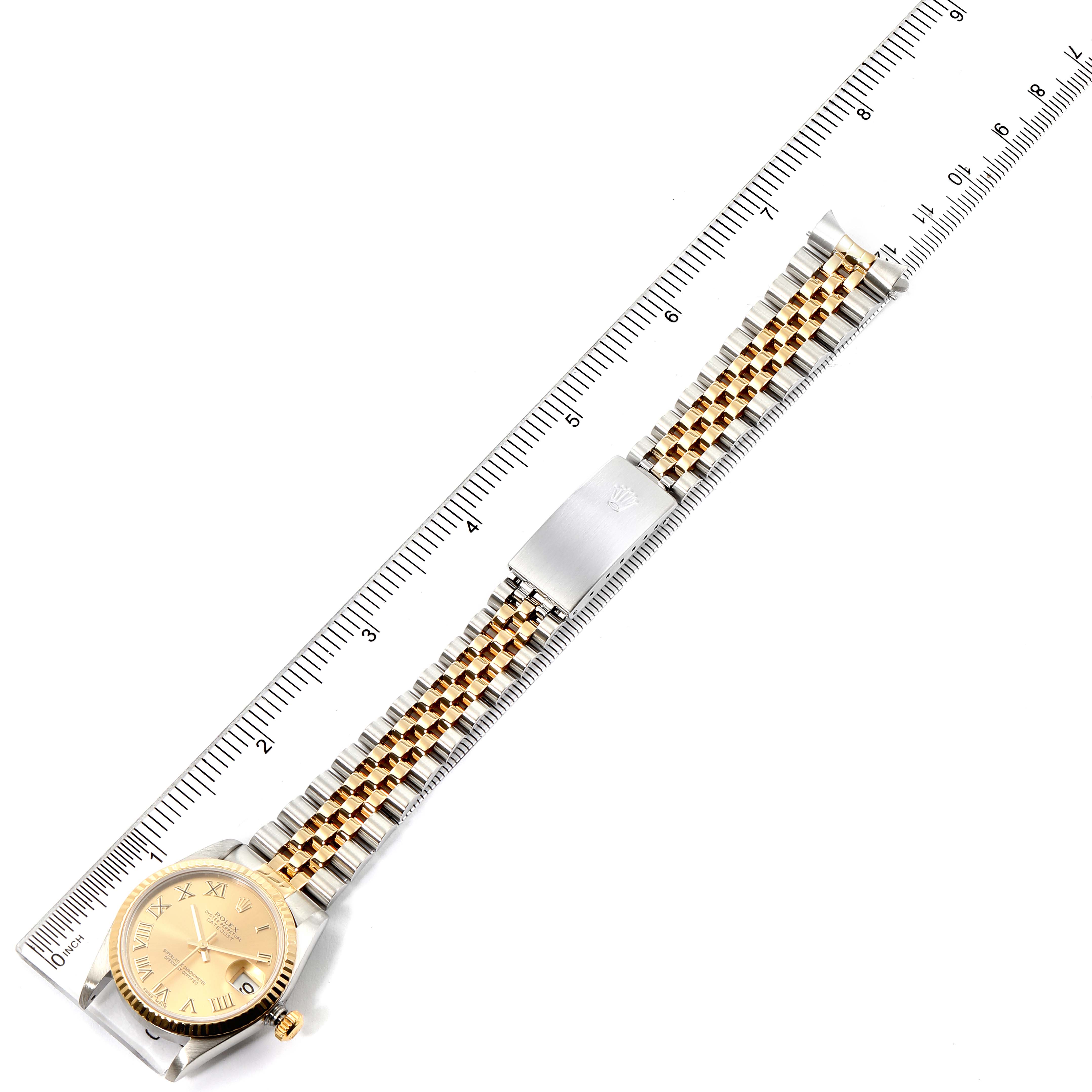 The image shows a top-down view of a Mid-Size Rolex watch with the face, dial, bracelet, and clasp visible, next to a ruler.