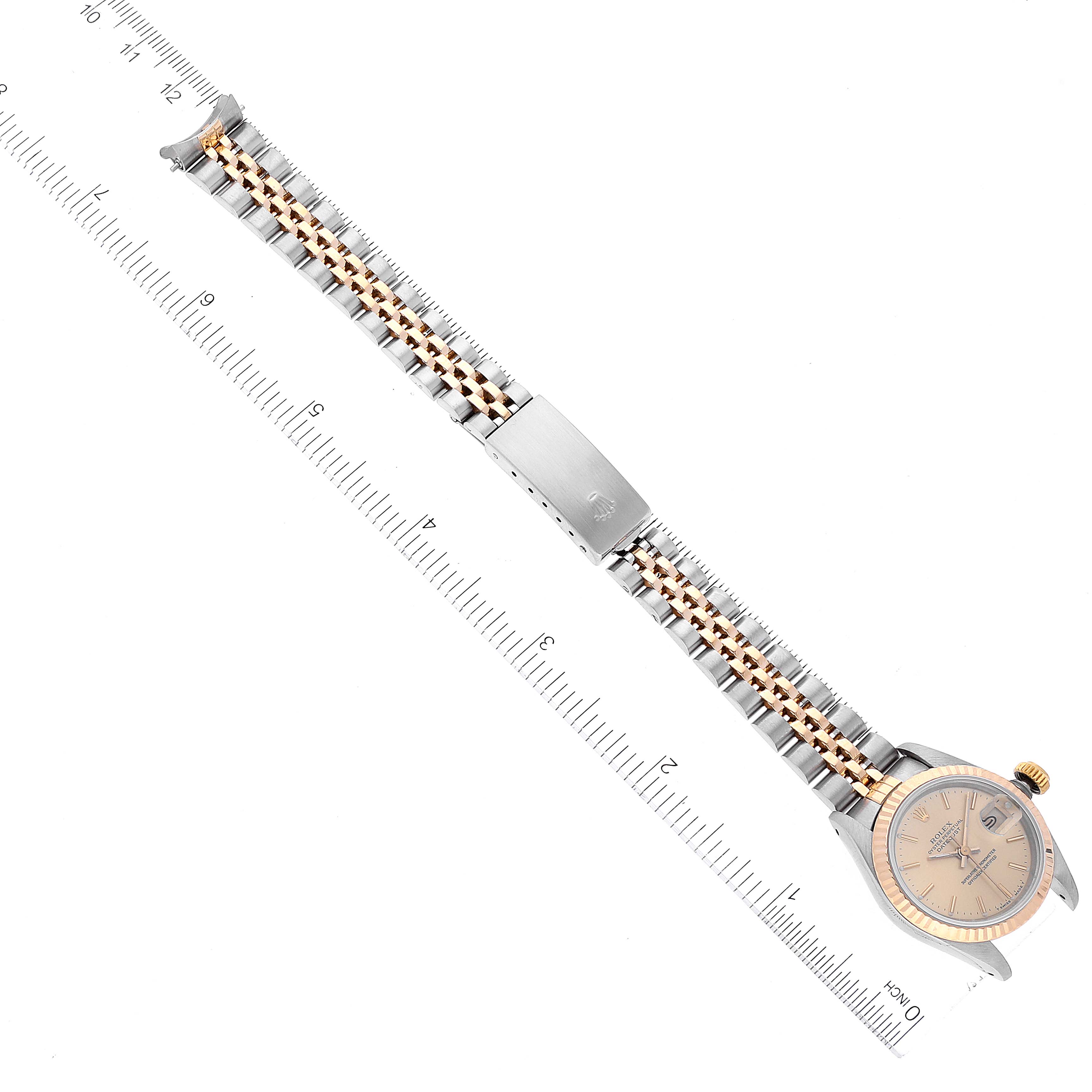 The image shows a top-down view of a Rolex Datejust 69173 Women's Steel and Gold (two tone) Champagne Dial 69173 Women's Steel and Gold (two tone) Champagne Dial watch, highlighting its face, case, and bracelet alongside a ruler for measurement.
