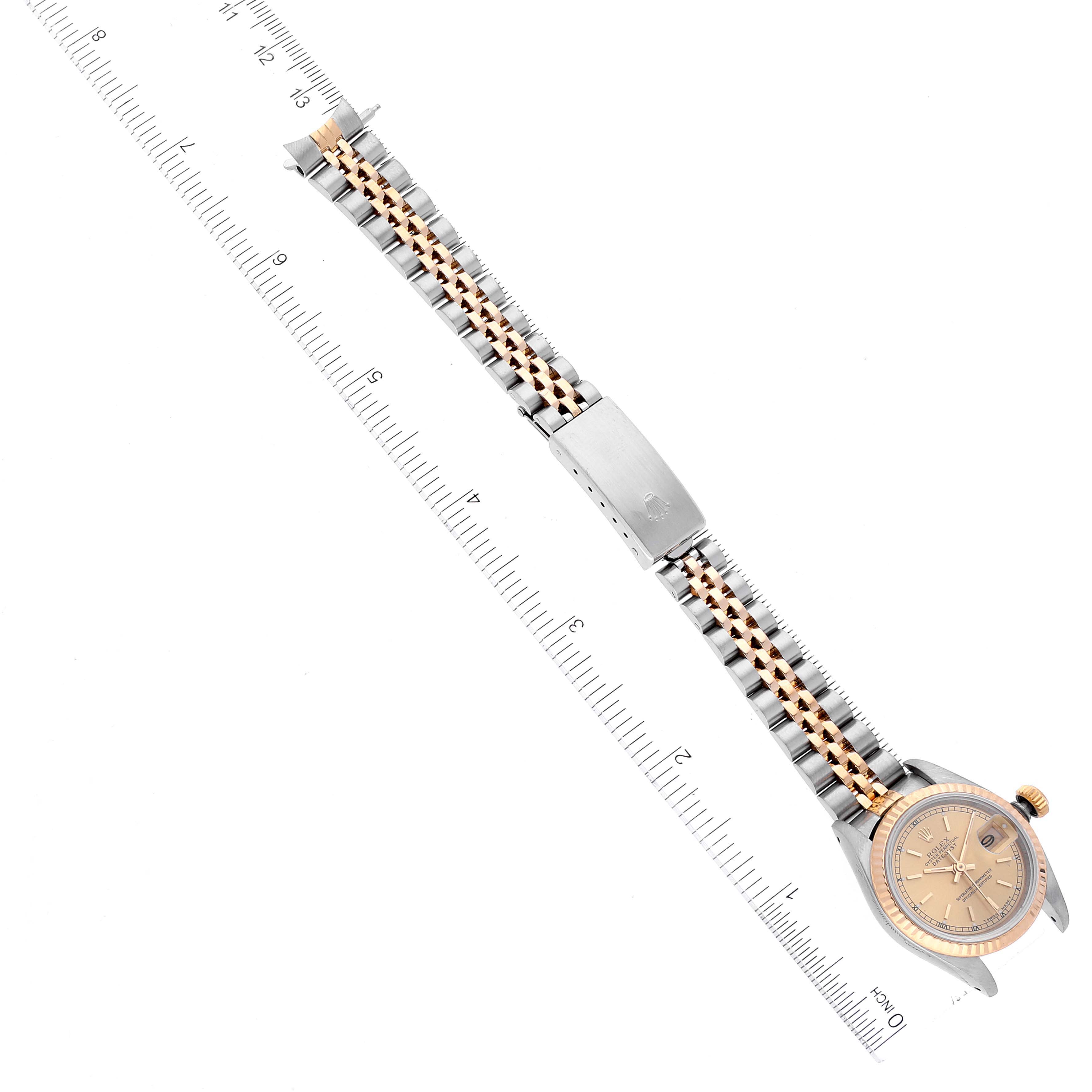 The image shows a top-down view of a Rolex Datejust 69173 Women's Steel and Gold (two tone) Champagne Dial 69173 Women's Steel and Gold (two tone) Champagne Dial watch, exhibiting the face, case, and bracelet alongside a ruler for scale.